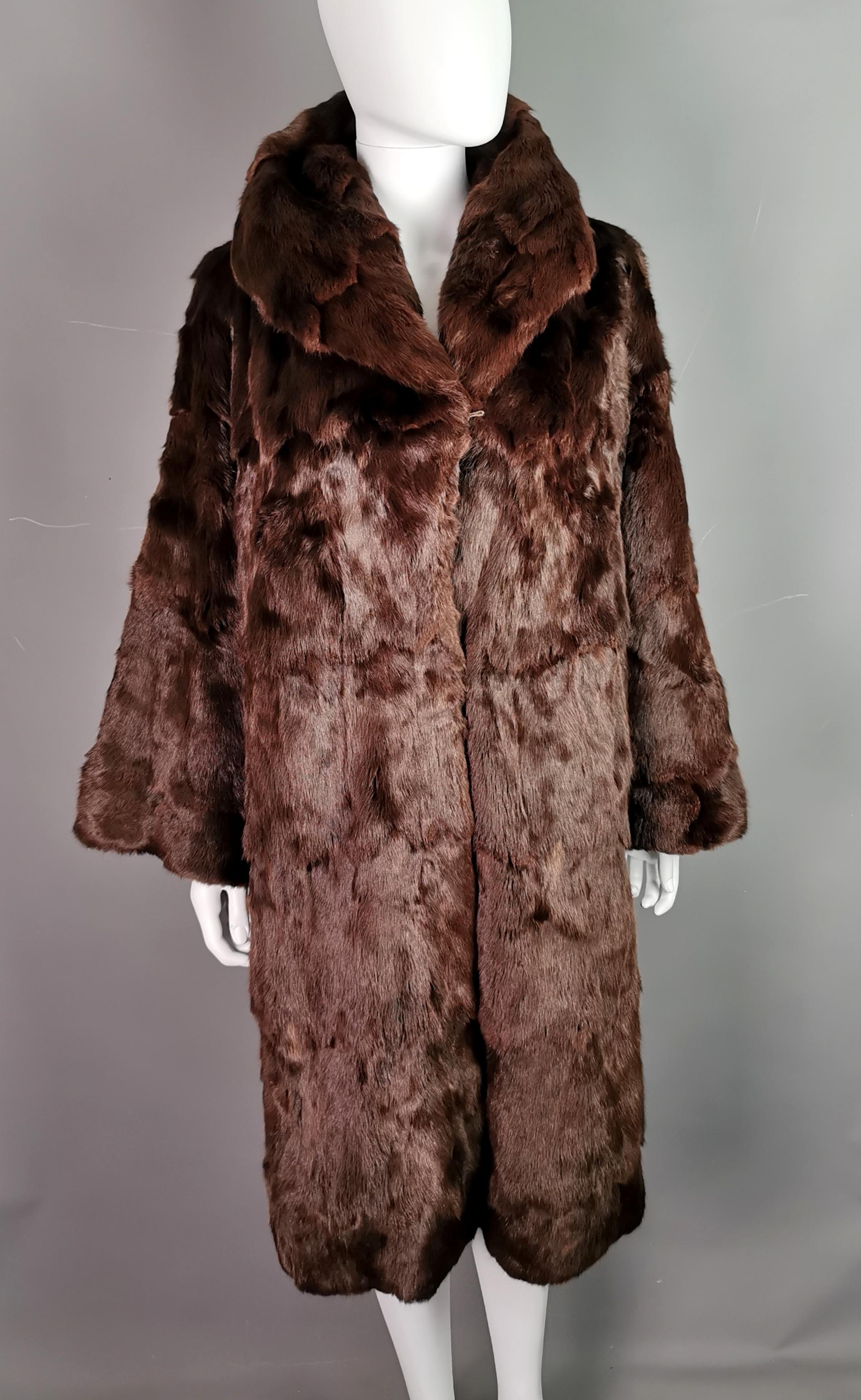 A very fine, high quality vintage mink fur swing coat.

It is made from mahogany brown mink fur, superbly soft and lined in a chocolate brown satin.

It has a nice wide collar with a longer yoke and wide super soft sleeves, a real bombshell
