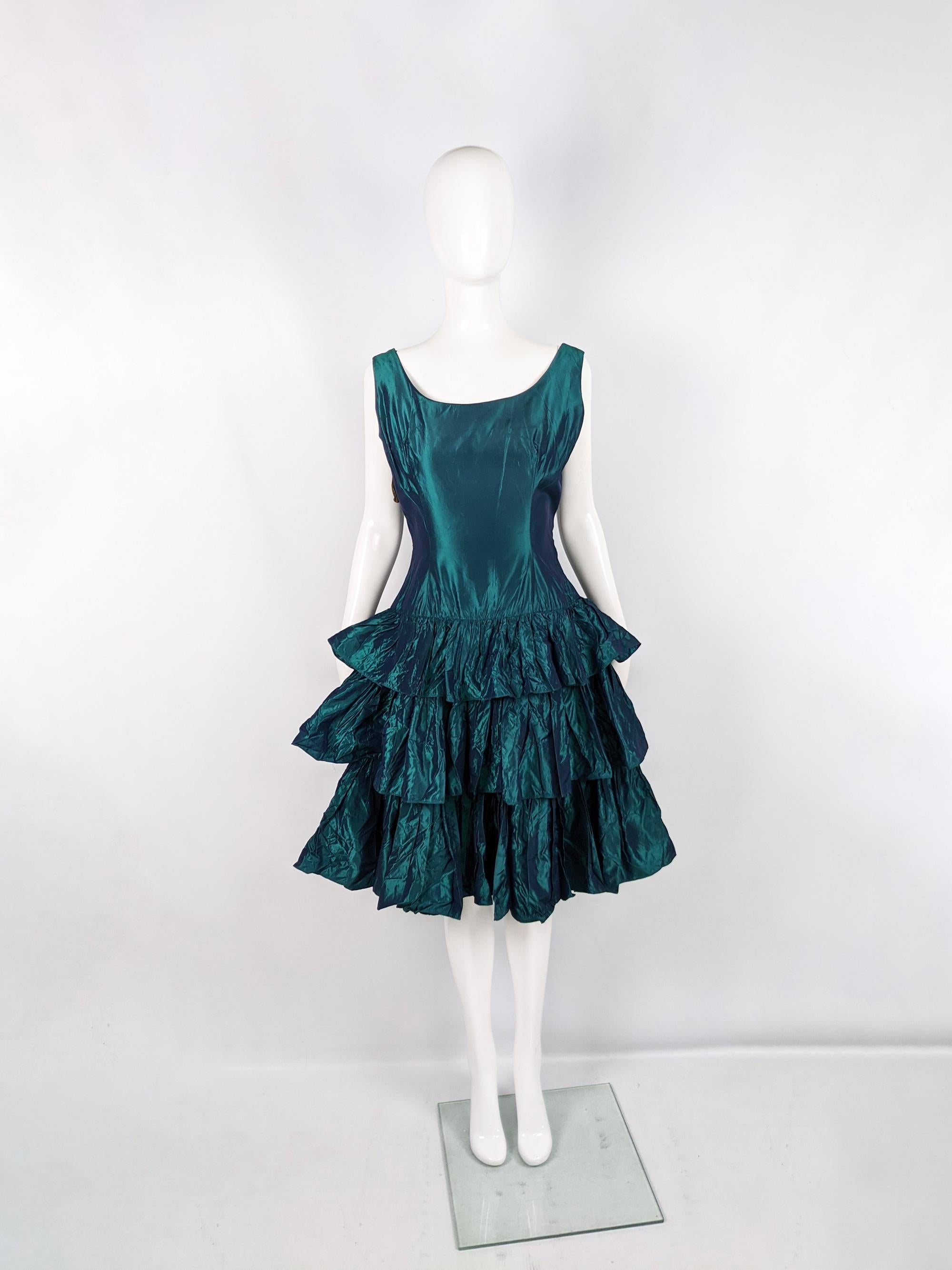 A stunning and rare vintage womens dress from the 1950s by quality British label, Miss London of Mayfair (one of the most expensive districts in the world). In a deep teal green iridescent taffeta fabric with a pleated, tiered skirt and drop waist.