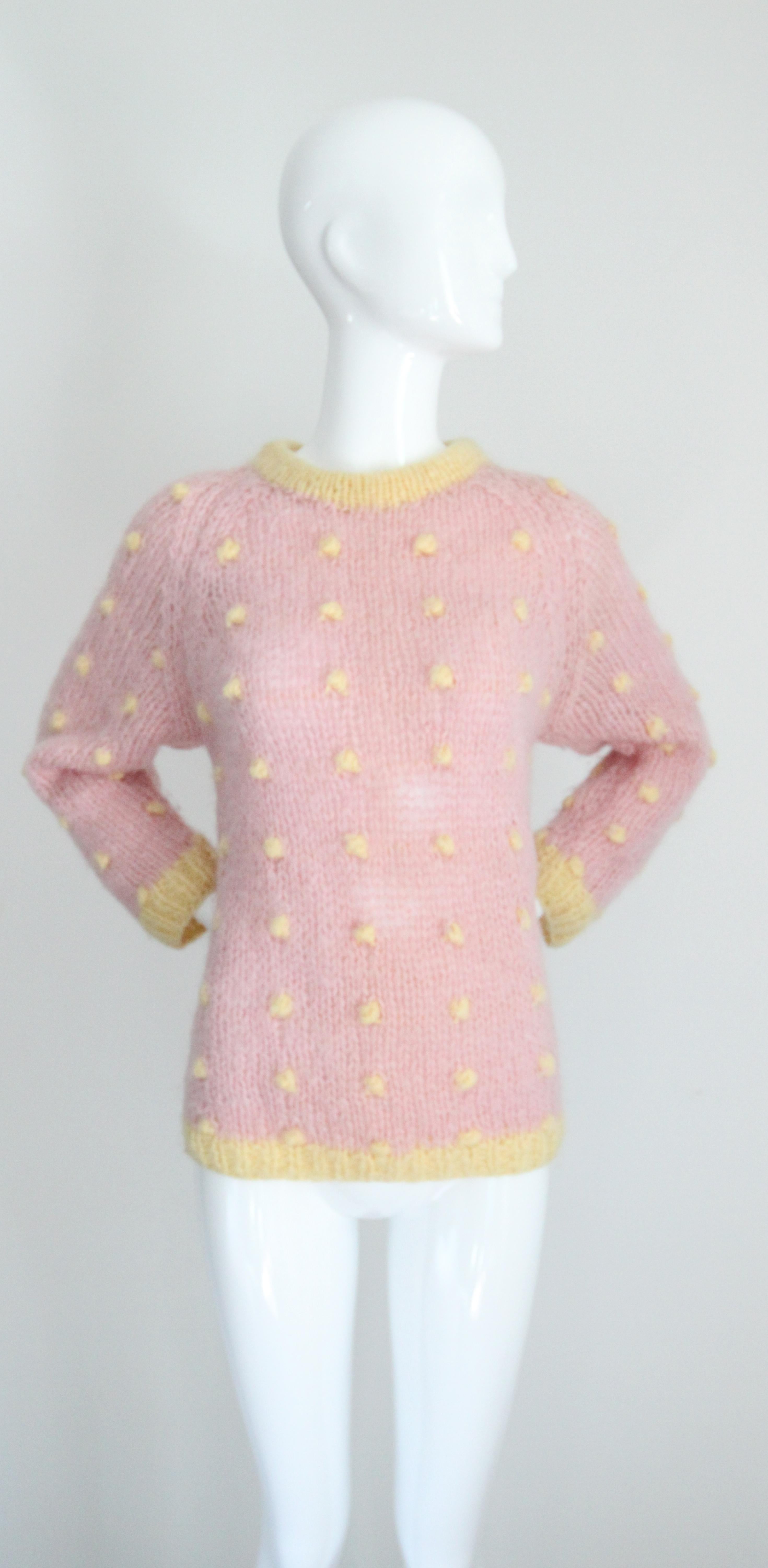 Le produit de base idéal pour les mois les plus froids. Réalisé dans une palette pastel de laine rose et jaune, avec un motif à pois en relief, ce pull tricoté original des années 1950 est exactement la pièce qu'il vous faut pour chasser le