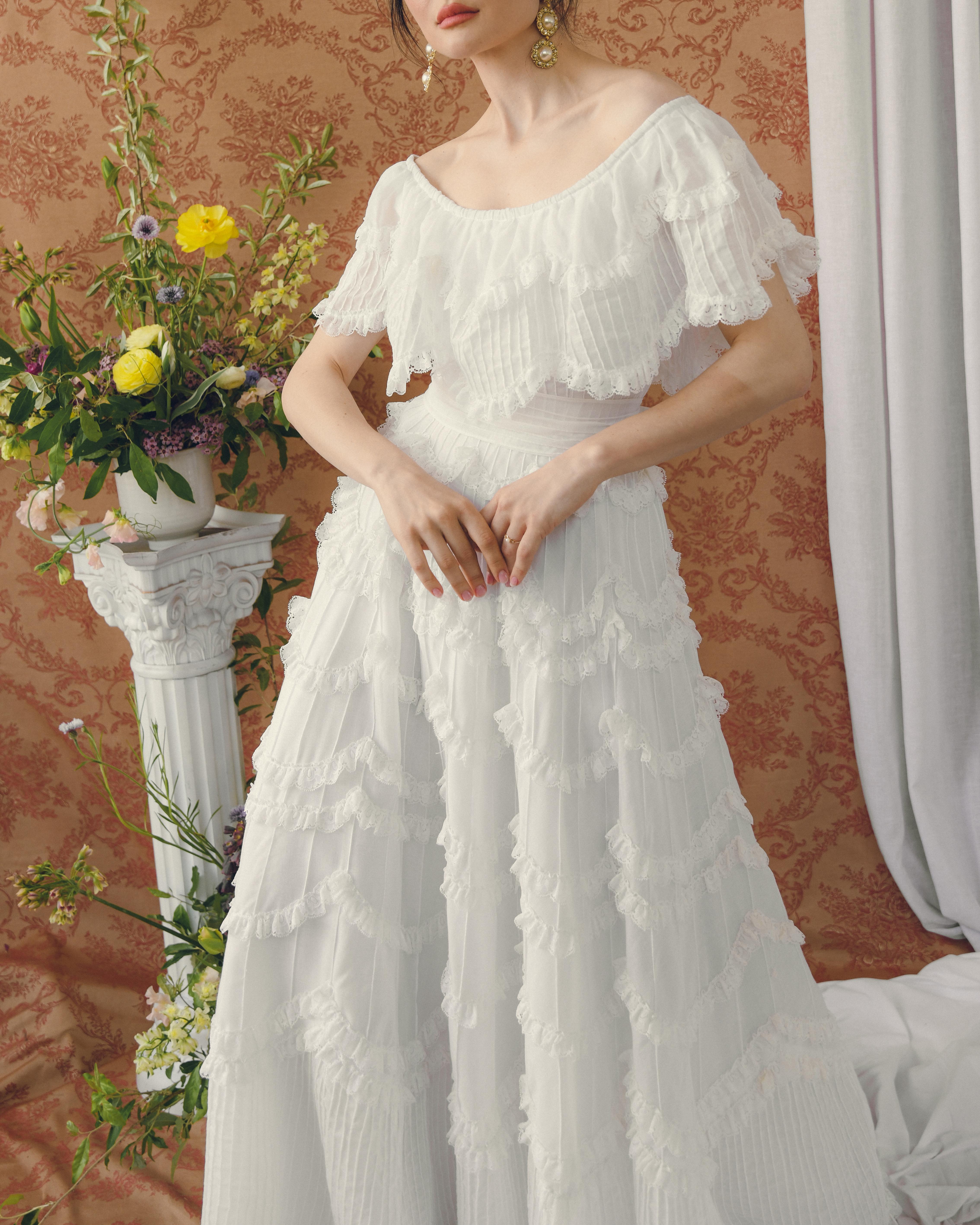 This vintage 1950s cotton lace dress is a rare example of its kind. Made in the 1950s, it features a slightly off-the-shoulder neckline, with beautiful pintucked details throughout, and lace trim in a scalloped shape— the craftsmanship is so