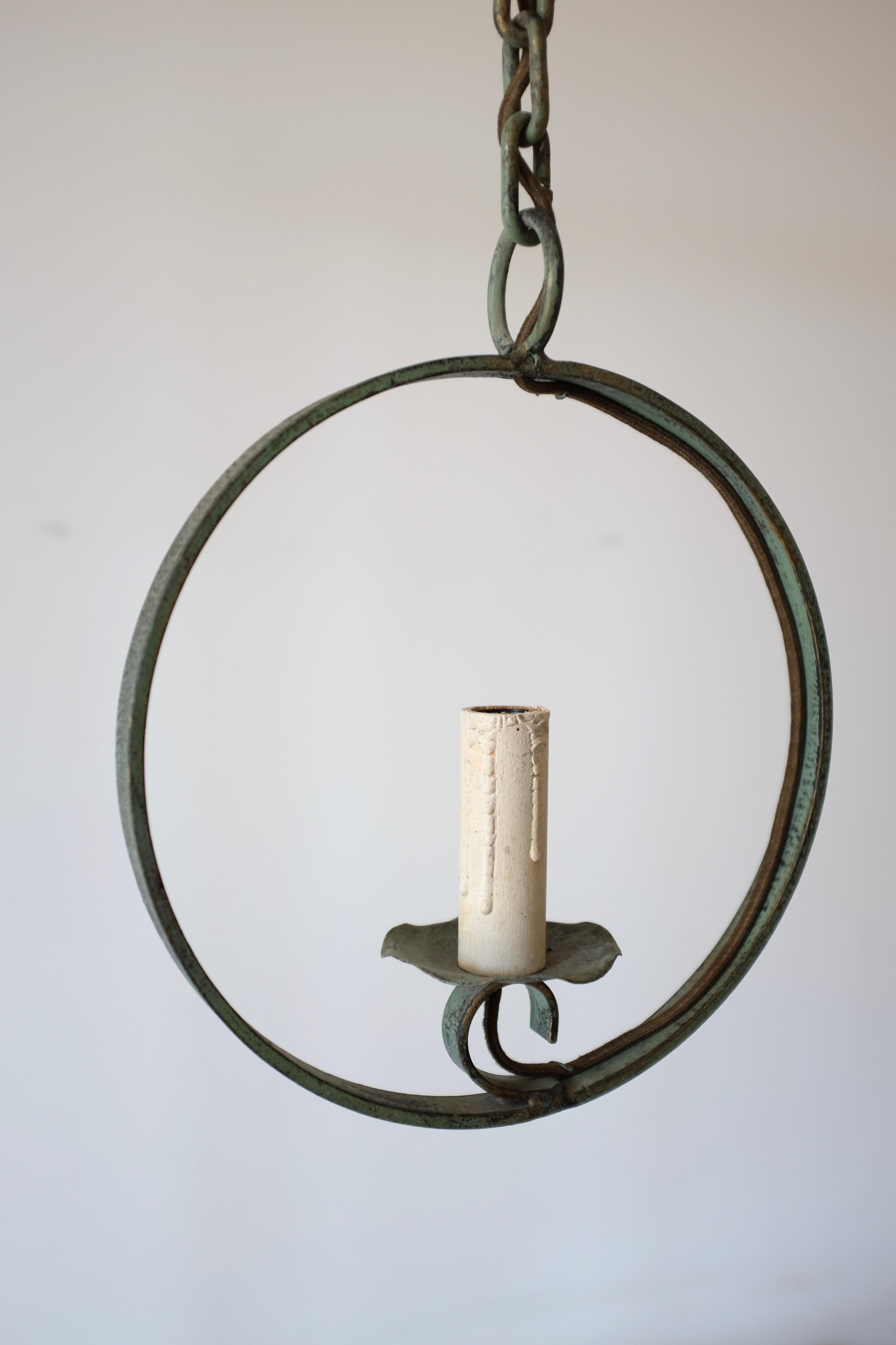 Charming 1950s outdoor pendant in the shape of a candle light within a circle. In a green metal with beautiful patina and organic details in the shape of a leaf around the lamp holder. In a good vintage condition with original wiring not tested, get