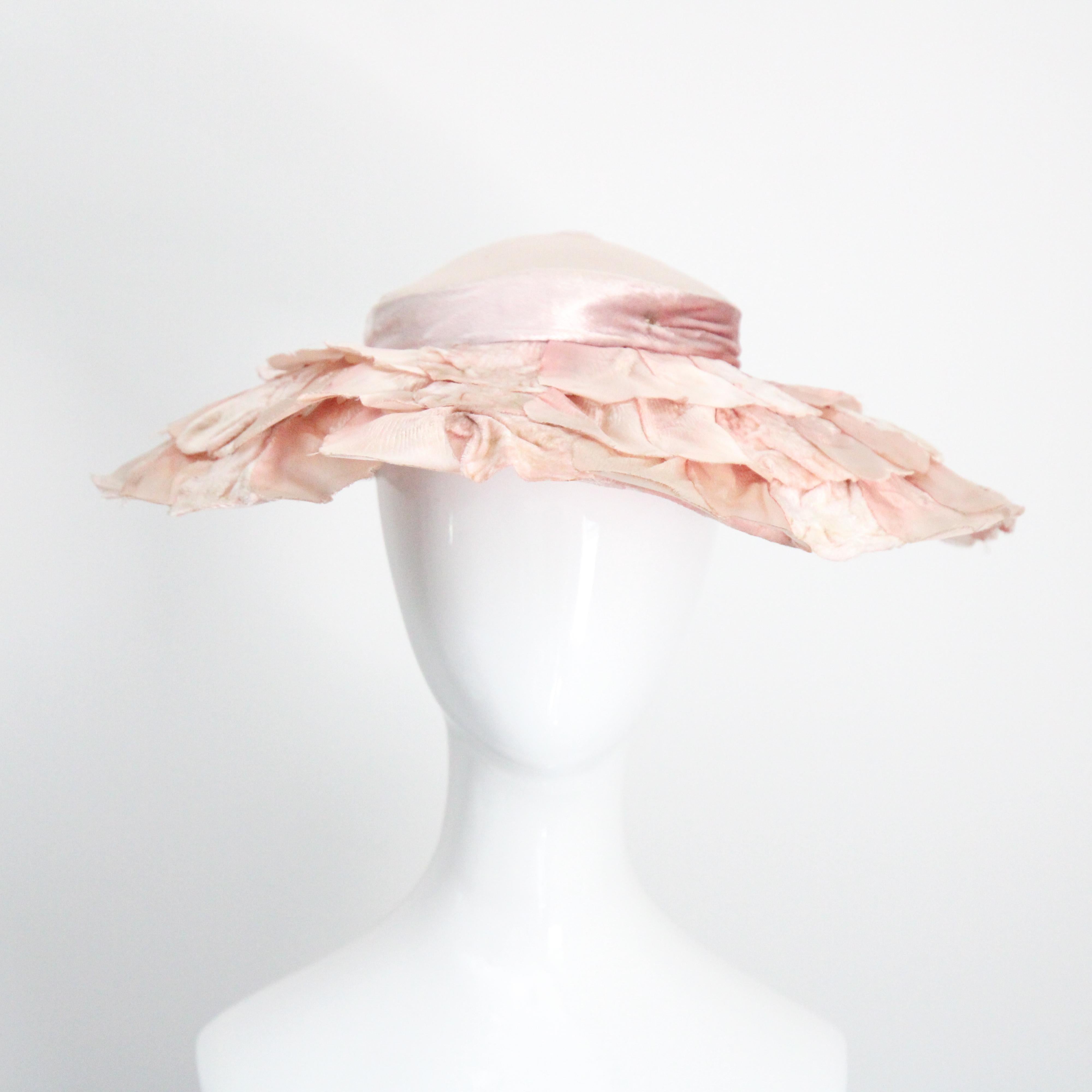 This beautiful 1950's ballerina pink velvet and rayon satin coloured saucer hat is the perfect statement piece for your hat collection. The moulded silk velvet crown, is accented by delicate gathered pleats along the edges and set off by a central