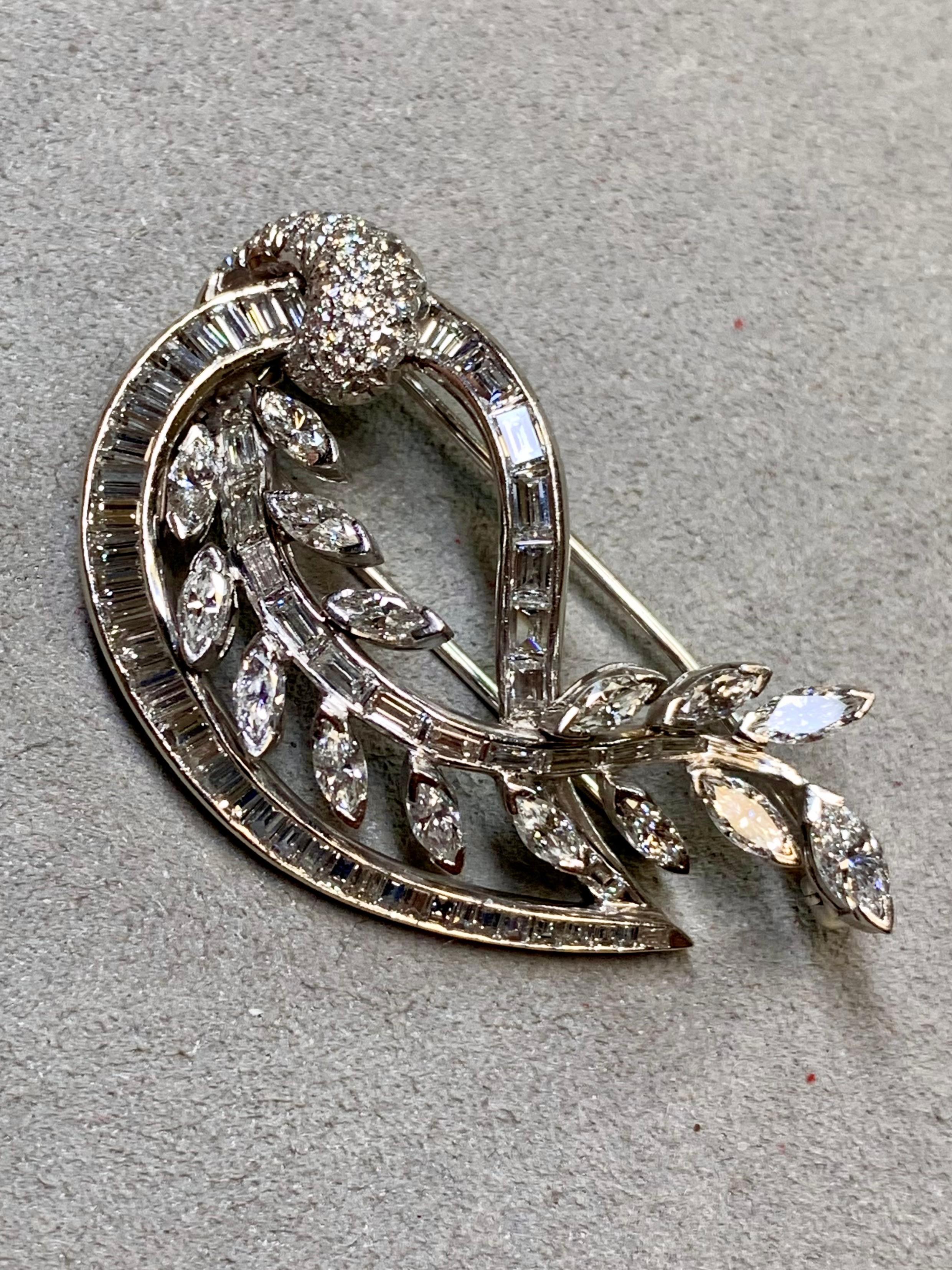 
Una straordinaria spilla in platino risalente agli anni '50, splendidamente realizzata in un'elegante Silhouette paisley con un motivo di foglie che si snoda al centro. Questo pezzo scultoreo è incastonato con circa 7,00 carati di diamanti