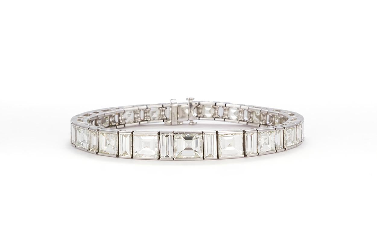 We are pleased to present this Beautiful Vintage Platinum & Diamond Graduated Line Bracelet circa 1950's. It features approximately 35.00ctw of O-P/VS-SI Carre and Baguette cut diamonds. They are securely set in this platinum line bracelet. The