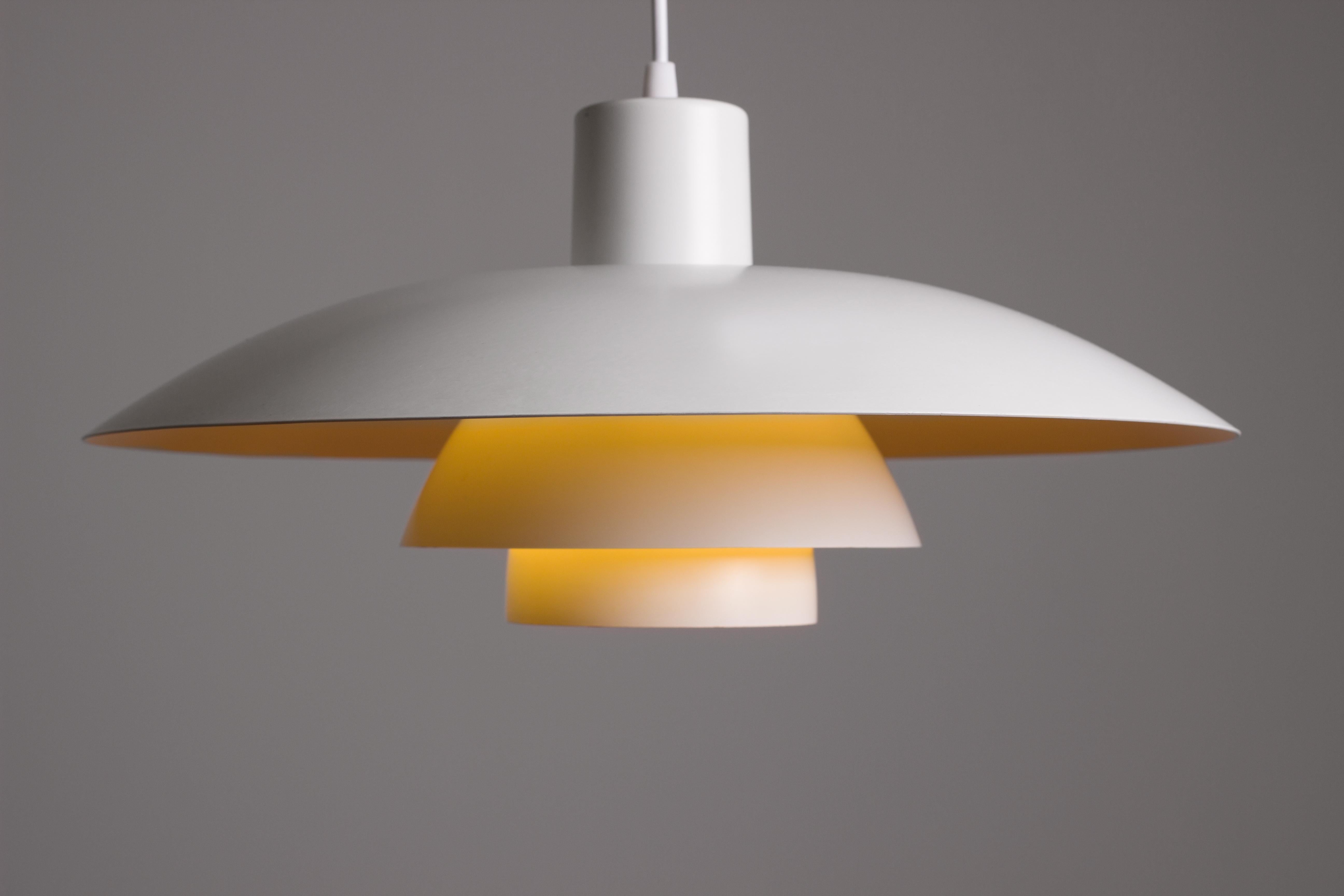 Poul Henningsen PH 4/3 pendant for Louis Poulsen. Vintage 1950s example with slightly yellowed paintwork and mild patina. Rewired. Beautiful and functional Scandinavian Modern design. Parabolic lenses ensures that only soft indirect light is spread