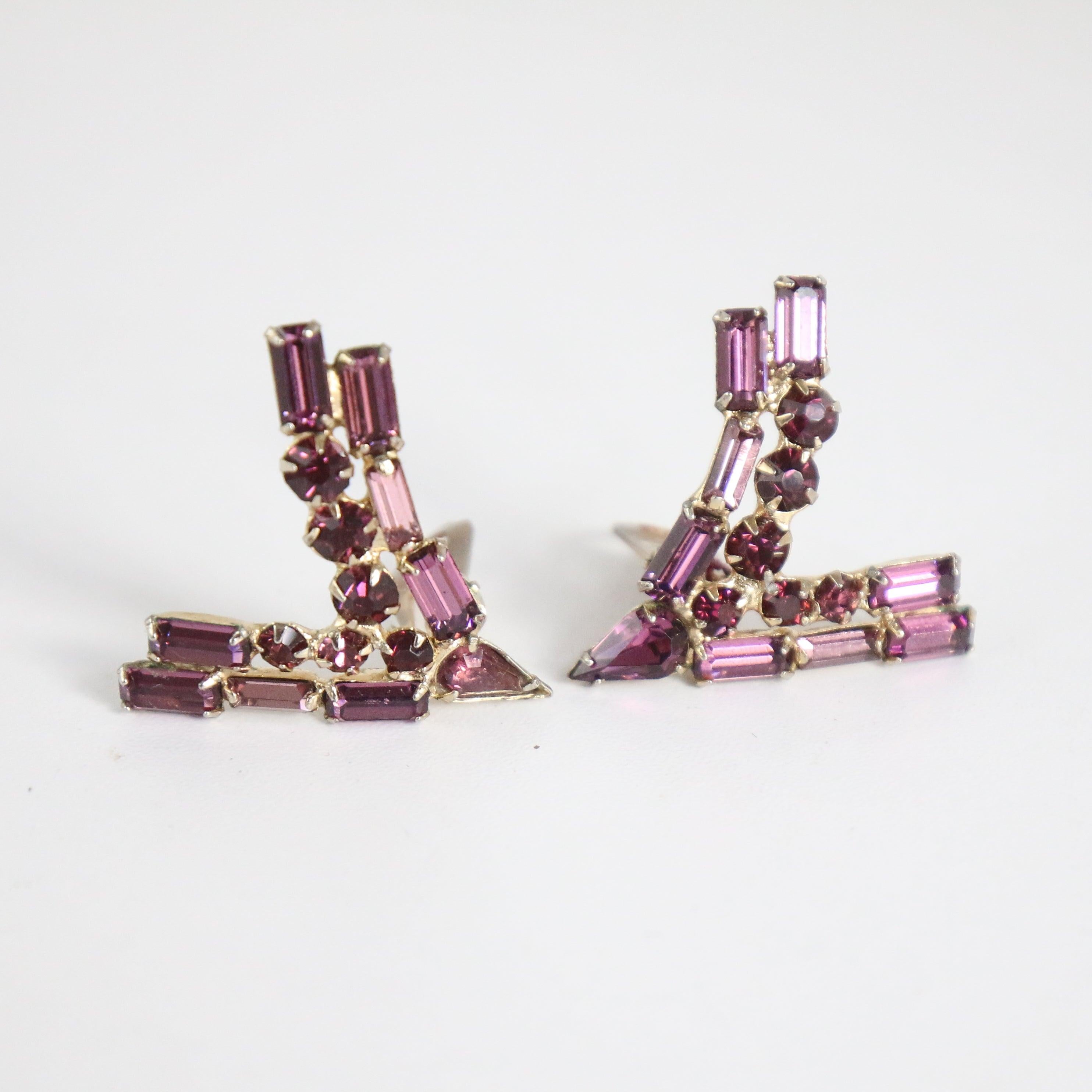 This dazzling pair of statement 1950's clip on earrings, made up of baguette, round and petal claw set violet purple rhinestones in a curved v shaped design, are the perfect finishing touch to any outfit.

Length: 1.4 inches 

Width: 1.3