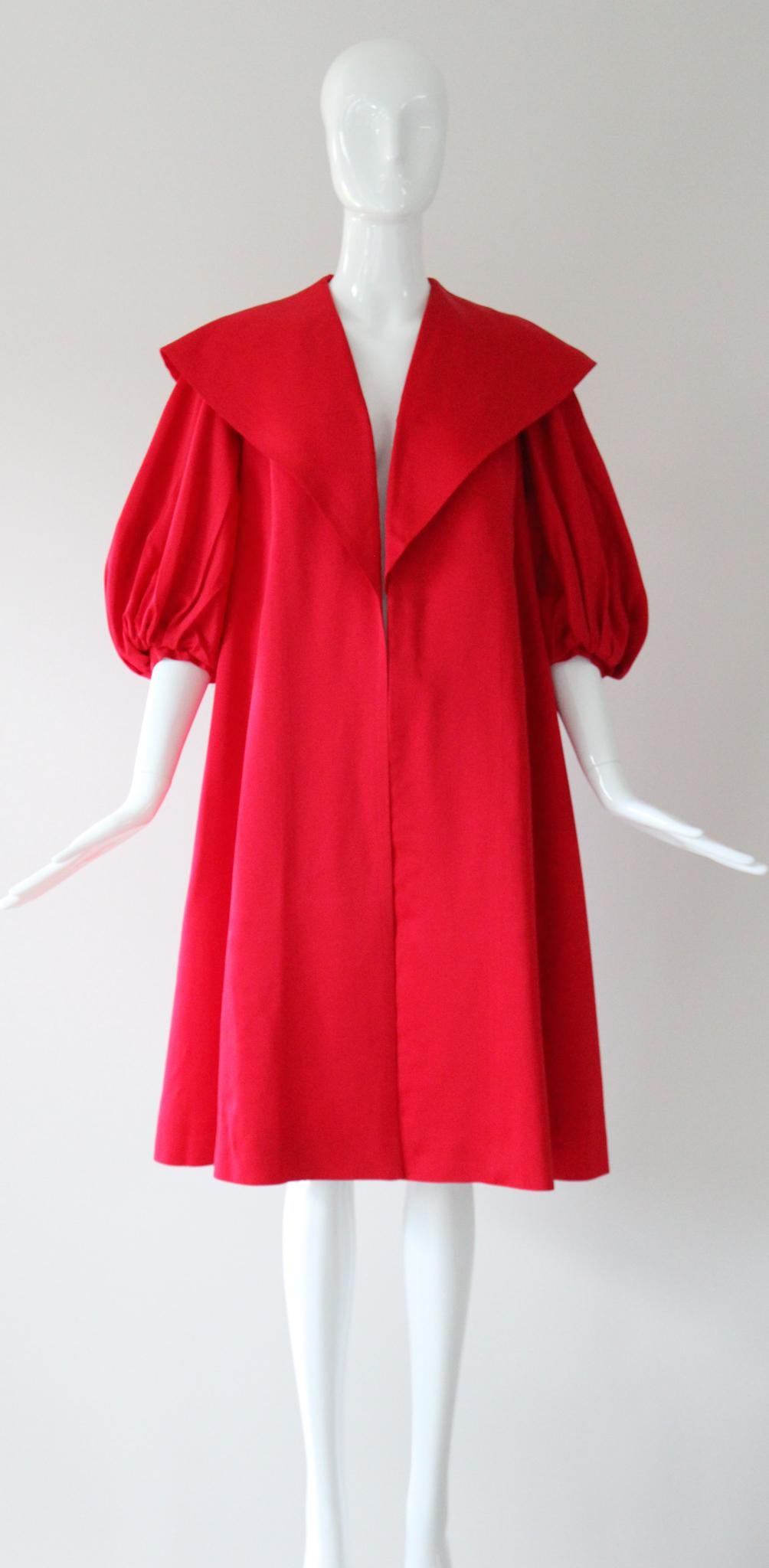 Realizzato nella più vibrante tonalità di raso di rayon rosso, in una silhouette iconica e senza tempo, questo originale cappotto swing vintage degli anni '50 sarà sicuramente uno dei preferiti della tua collezione vintage.

La scollatura a V è