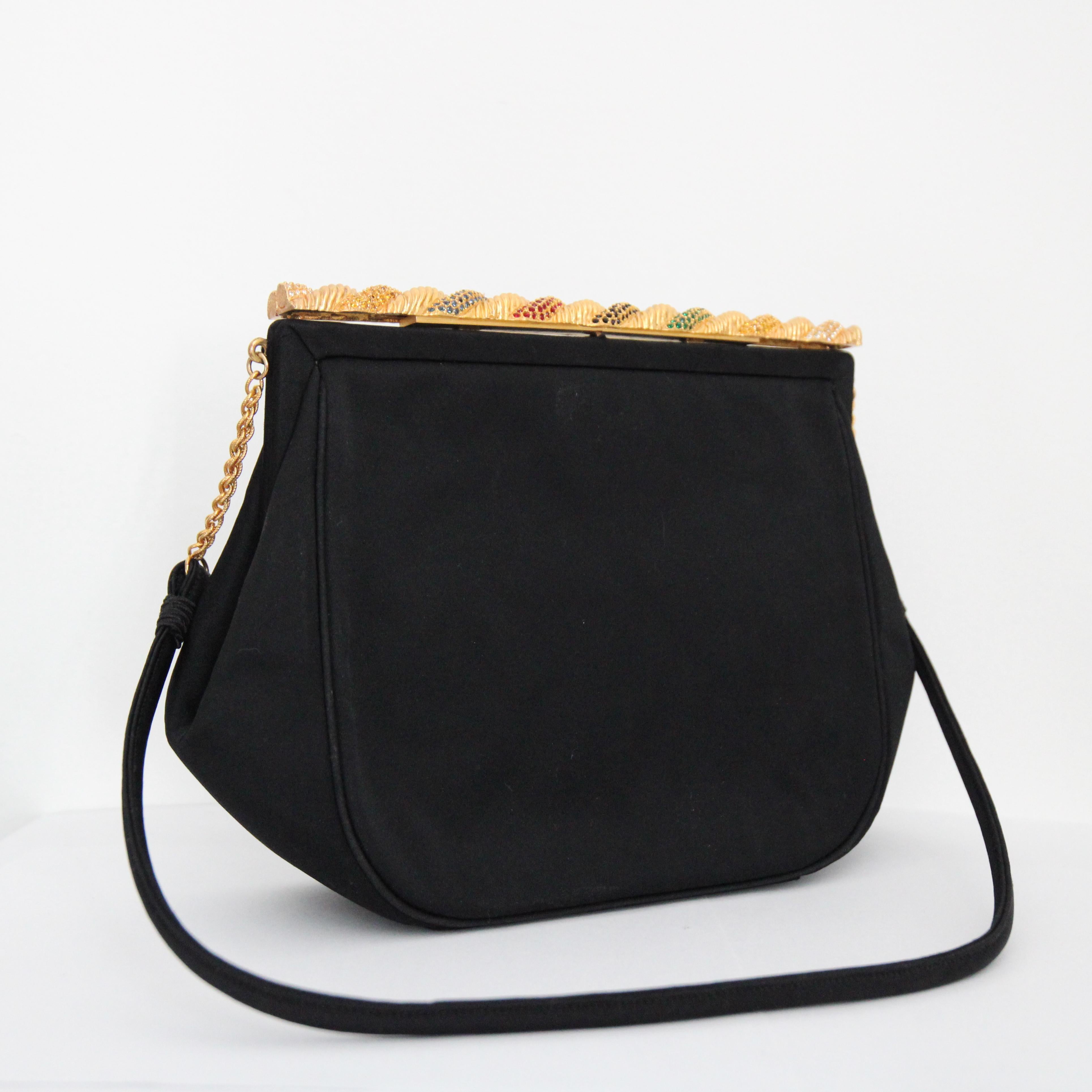 Rendered in the smoothest black faille, which boast an almost satin like finish and accented by a gold toned clasp embellished with rhinestones, this original 1950's handbag is sure to be your favourite new piece. 

The elegant lift lock clasp of