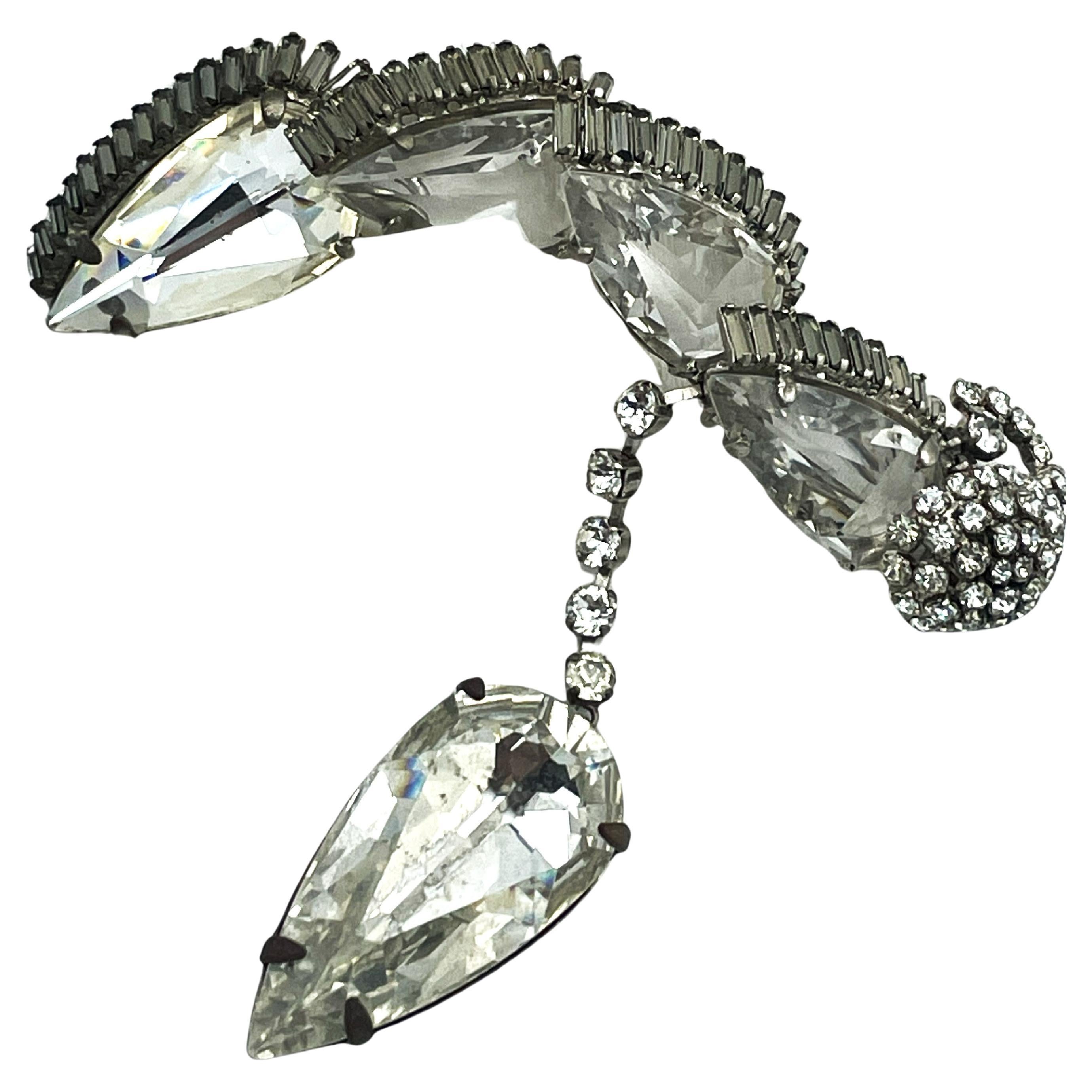 Rare broche en strass de Roger Jeane-Pierre Paris, datant du début des années 1950.
Une broche vintage très élégante de Roger Jeane Pierre Paris datant du début des années 1950. La broche a un format horizontal avec 4 grands cristaux taillés en