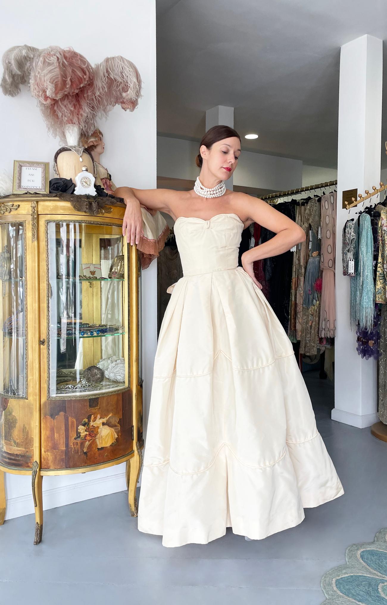 An absolutely breathtaking and incredibly rare Rosalie Macrini cream silk taffeta strapless full skirted ballgown dating back to the late 1950's. Rosalie Macrini had her start designing for the famous Barbara Costume Company in New York, going on to