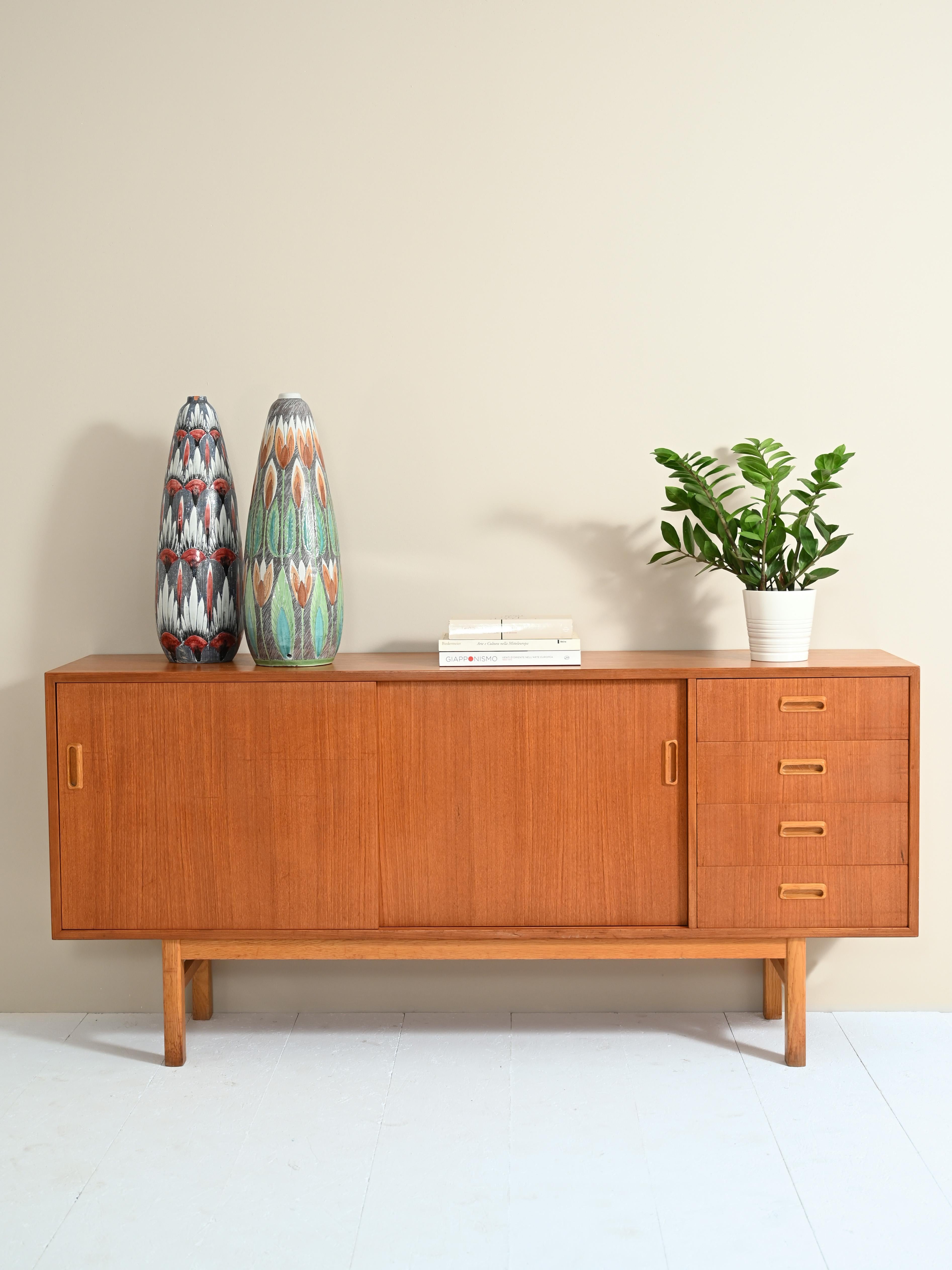 Original sideboard cabinet from the 1950s with sliding doors and drawers.

The classic and typical lines of the period are enriched with fine details such as the special carved wooden handles. Inside the compartment there is a shelf, while on the