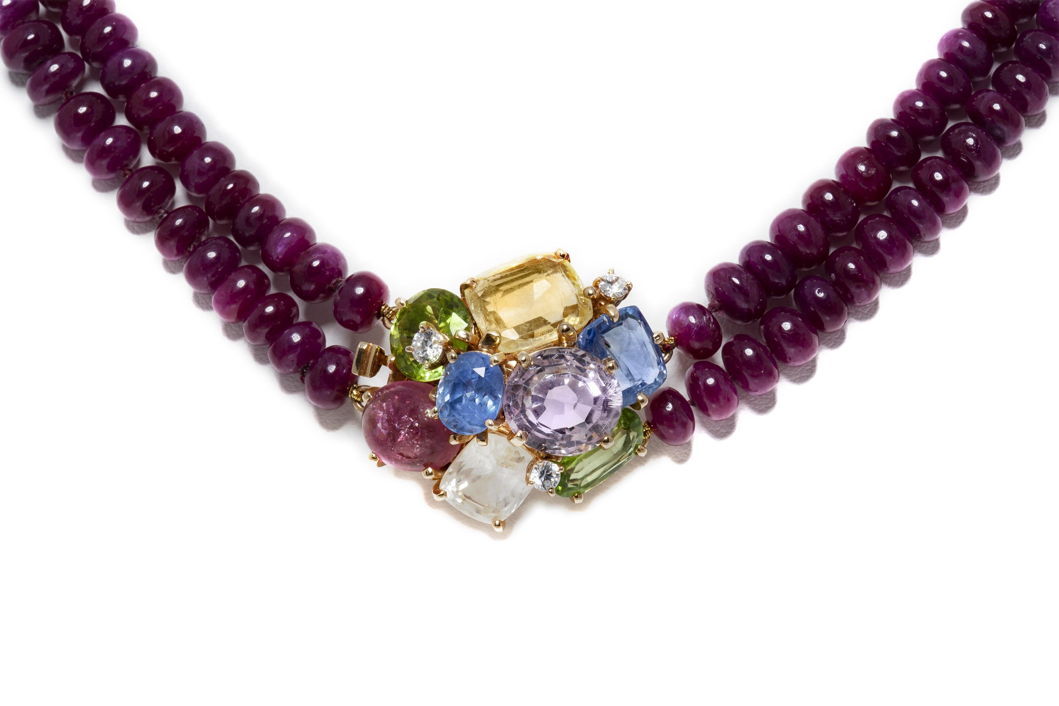 Finemente realizzato con 2 fili di perline di rubino e una chiusura in oro giallo 14k con pietre multicolore che includono diamanti, peridoti, rubino, kunzite e altro ancora. 
Firmato dal Seaman Schepps
Circa anni '50
21 3/4 pollici di lunghezza
