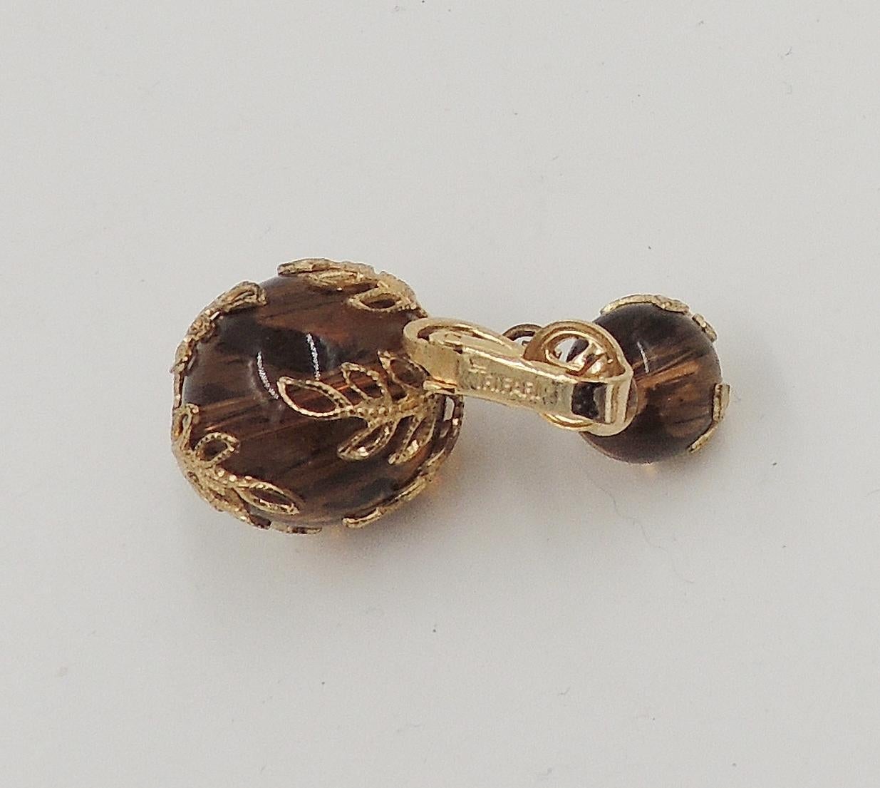 Early 1950s goldtone filigree striated semi-translucent Lucite faux-tortoise clip back earrings. Marked 