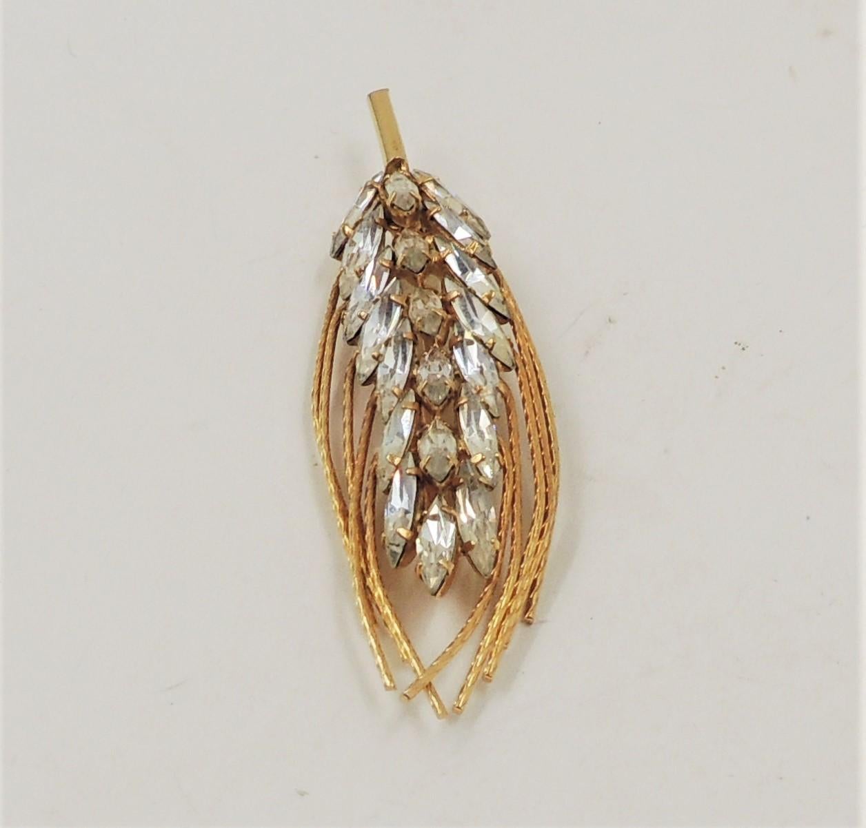 Goldtone marquise clear rhinestone wheat sheaf brooch with security clasp. Measures: 3 inches wide by 7/8 inches tall. Condition: Very good; minor wear, signature is very faint. 

Vintage Napier jewelry was made in Meridan, Connecticut and is very
