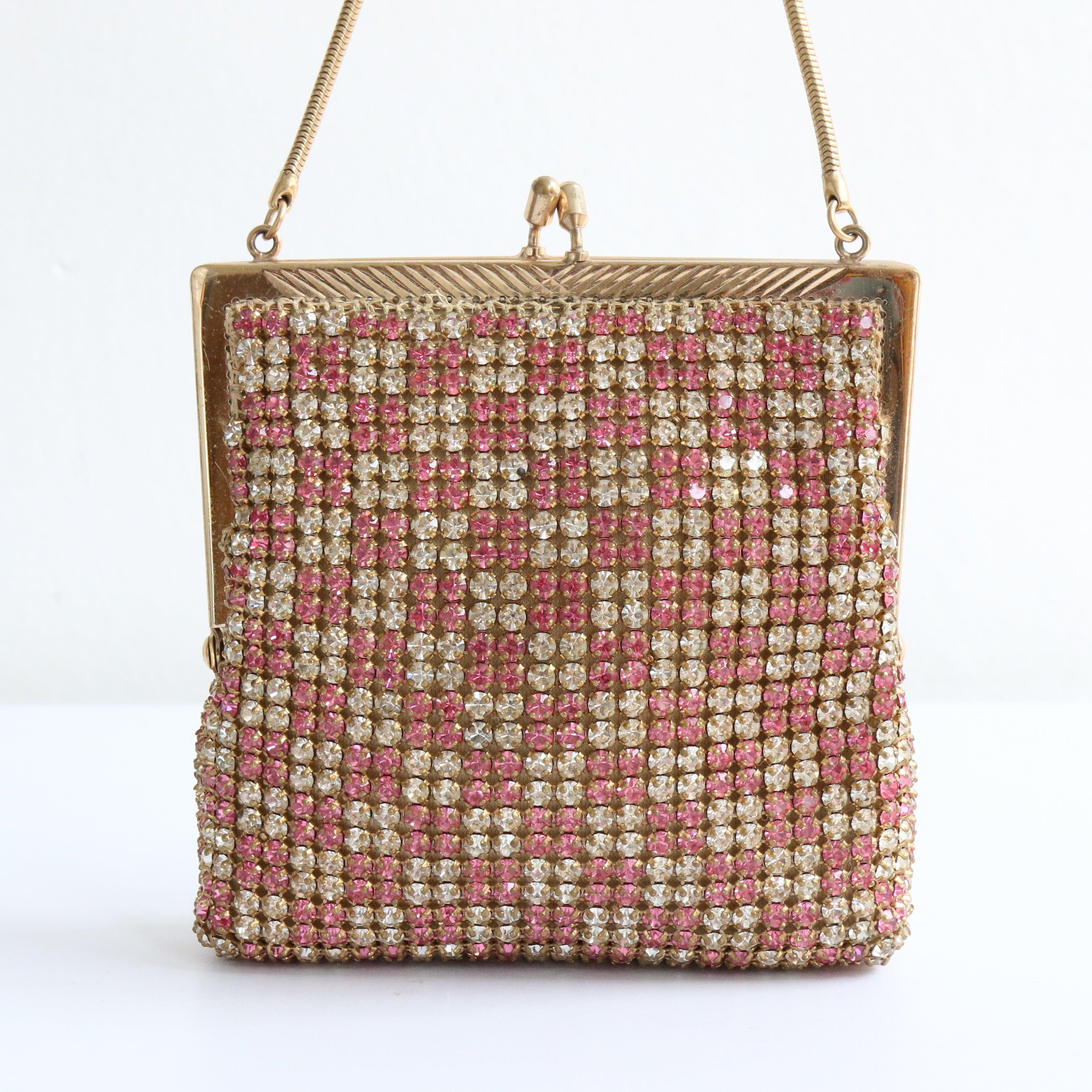 Ein funkelndes Highlight für Ihre Cocktailgarderobe. Diese Abendtasche aus den 1950er Jahren, die mit silbernen und rosafarbenen Strasssteinen im Schachbrettmuster verziert ist, ist die perfekte Ergänzung für Ihre Accessoire-Sammlung.  

Die