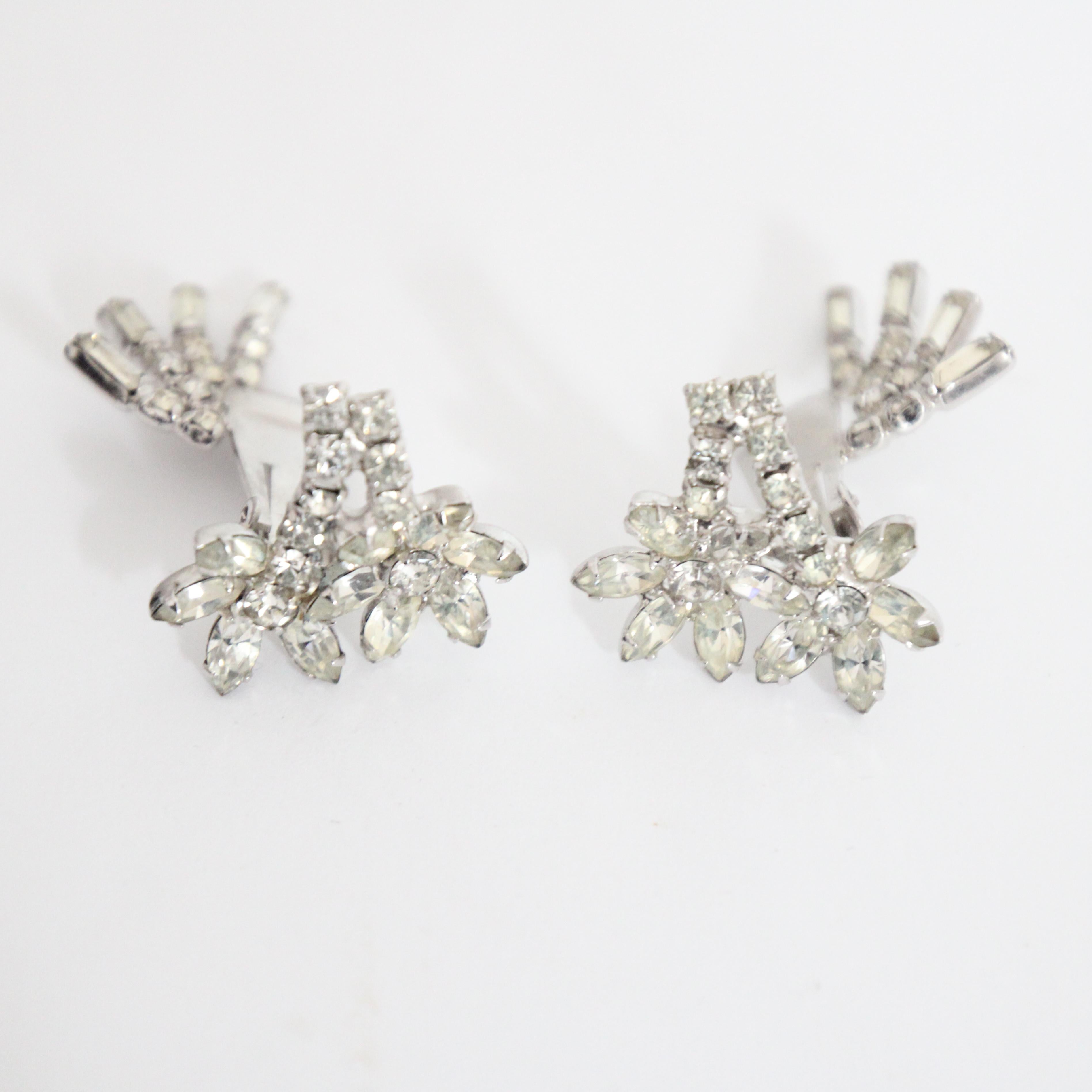 Este maravilloso par de pendientes trepadores de los años 50, con un fascinante diseño de margaritas de brillantes, son la pieza perfecta para tu colección de joyas.  La base de los pendientes presenta dos diseños de margaritas de strass, que se