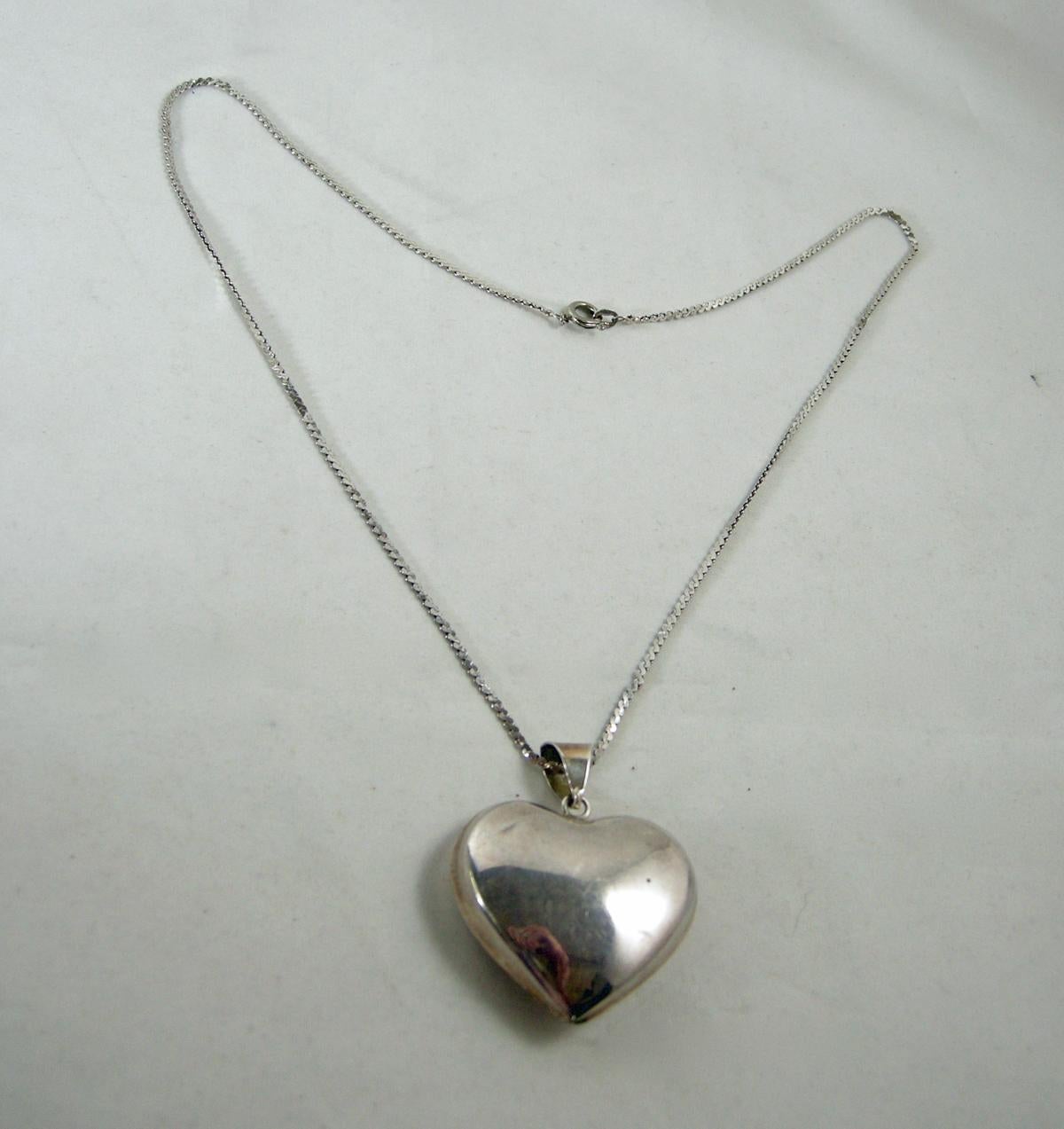 This vintage 1950’s sterling silver heart pendant heart is connected to a sterling S-link chain.  In excellent condition, the heart pendant measures 1-7/8” x 1-1/2”. The S-link chain is 20” x 1/16” with a spring clasp.