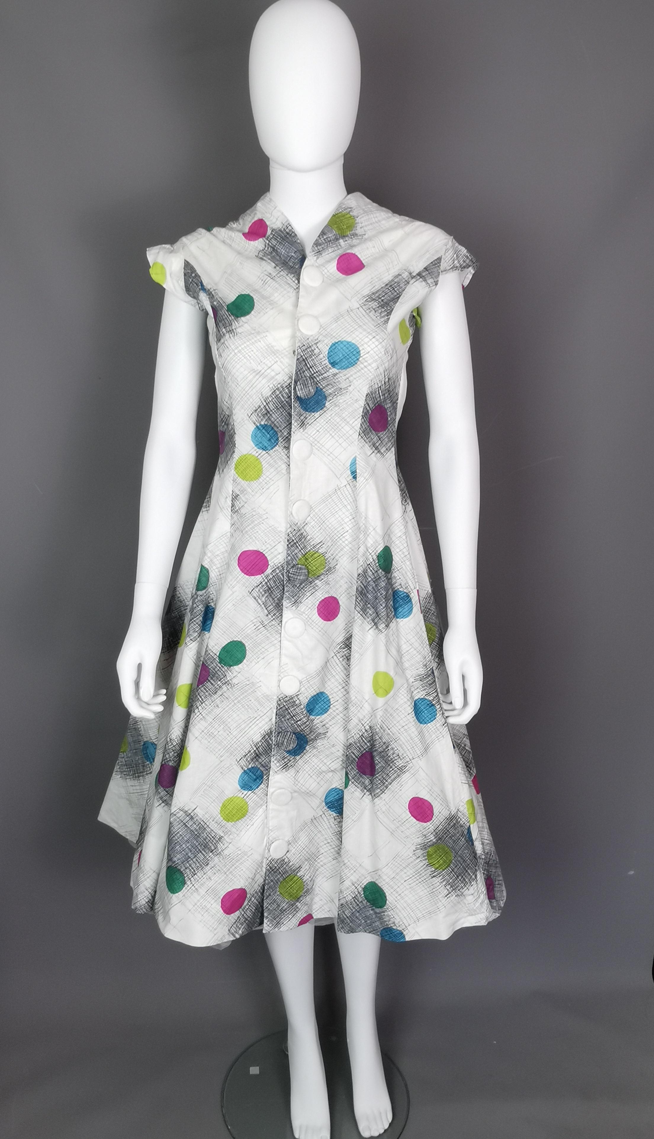 An incredible vintage original 1950s two piece dress.

It features a wonderful full skirted swing dress with a matching short sleeved bolero jacket.

The set is made from cotton with an abstract circles, space age style print.

It has a gorgeous and