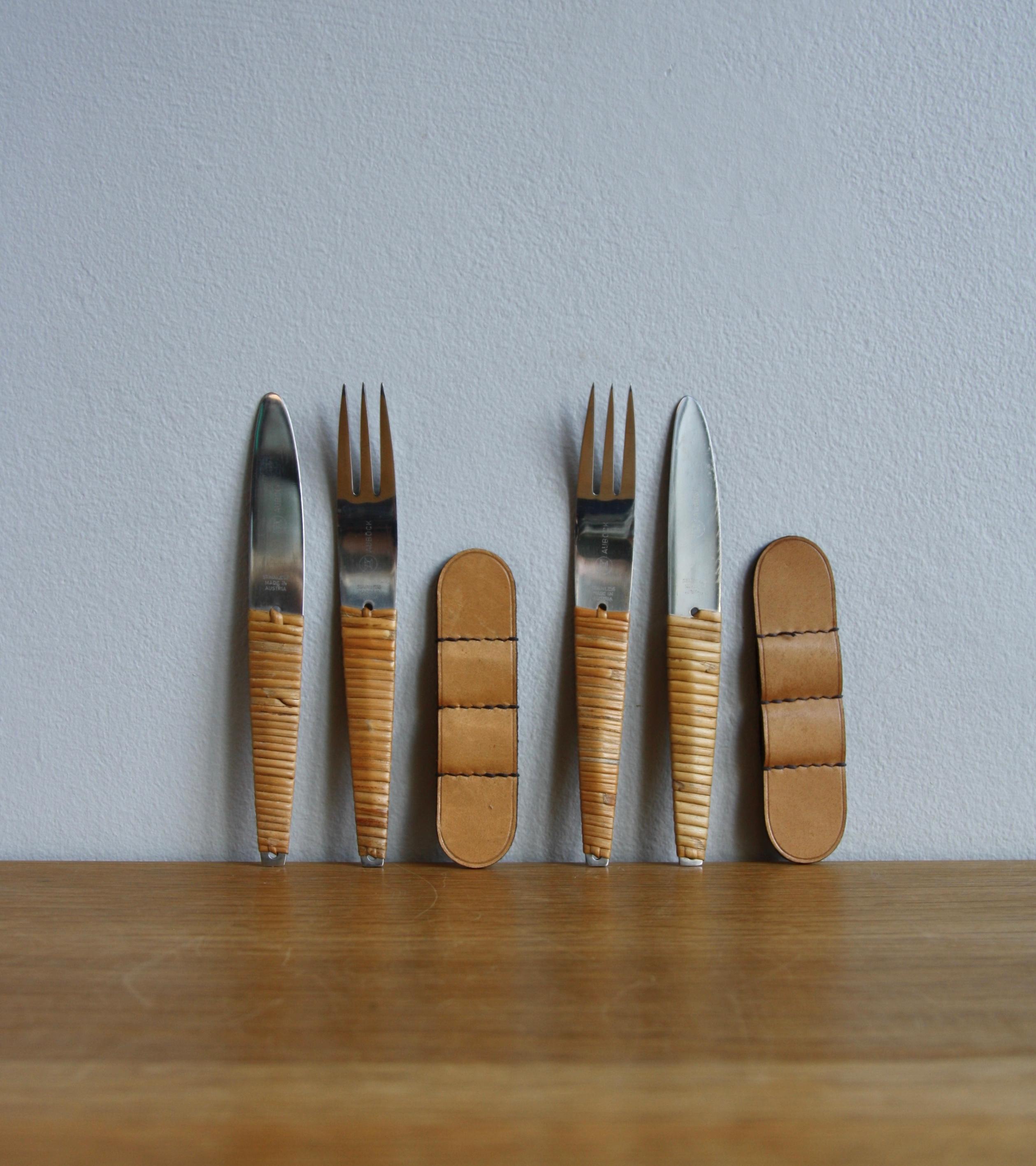 Deux ensembles vintage de couteaux et fourchettes, numéro de modèle #4244, par l'atelier Auböck, Vienne, vers 1950.
Le corps des couverts est en acier inoxydable, le manche de chaque pièce est tressé avec de la canne d'osier. Chaque set est