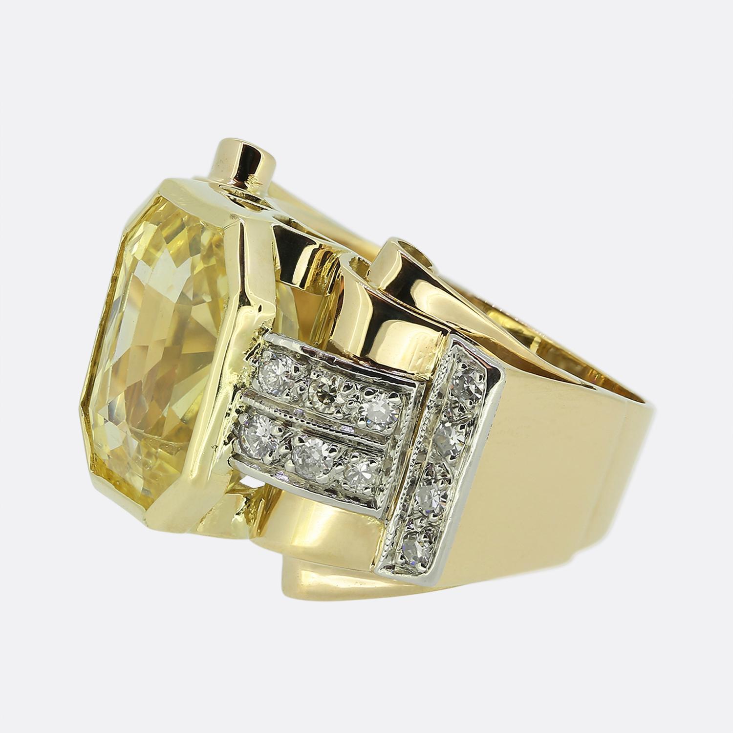 Ecco un audace anello in oro giallo 18ct risalente alla metà del XX secolo. Al centro del quadrante troviamo un impressionante zaffiro di Ceylon di forma ottagonale da 11,66 carati che possiede un'accattivante tonalità di colore giallo naturale.