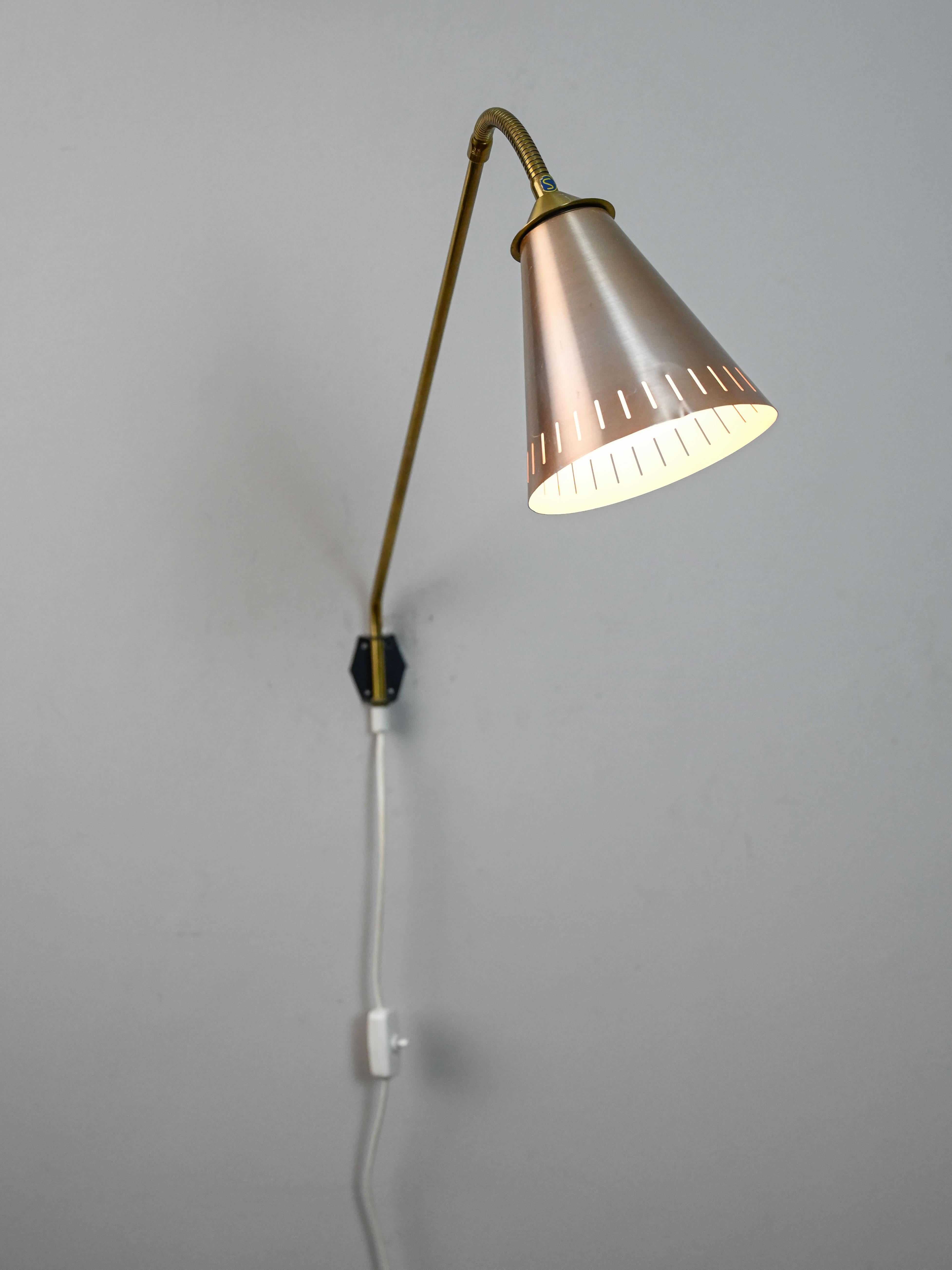 Aplique direccional de fabricación escandinava. 

Esta pieza de diseño sueco vintage consta de un brazo de metal dorado y una pantalla de chapa cromada.
Con la posibilidad de dirigir la luz, puede utilizarse como lámpara de mesa, de dormitorio o