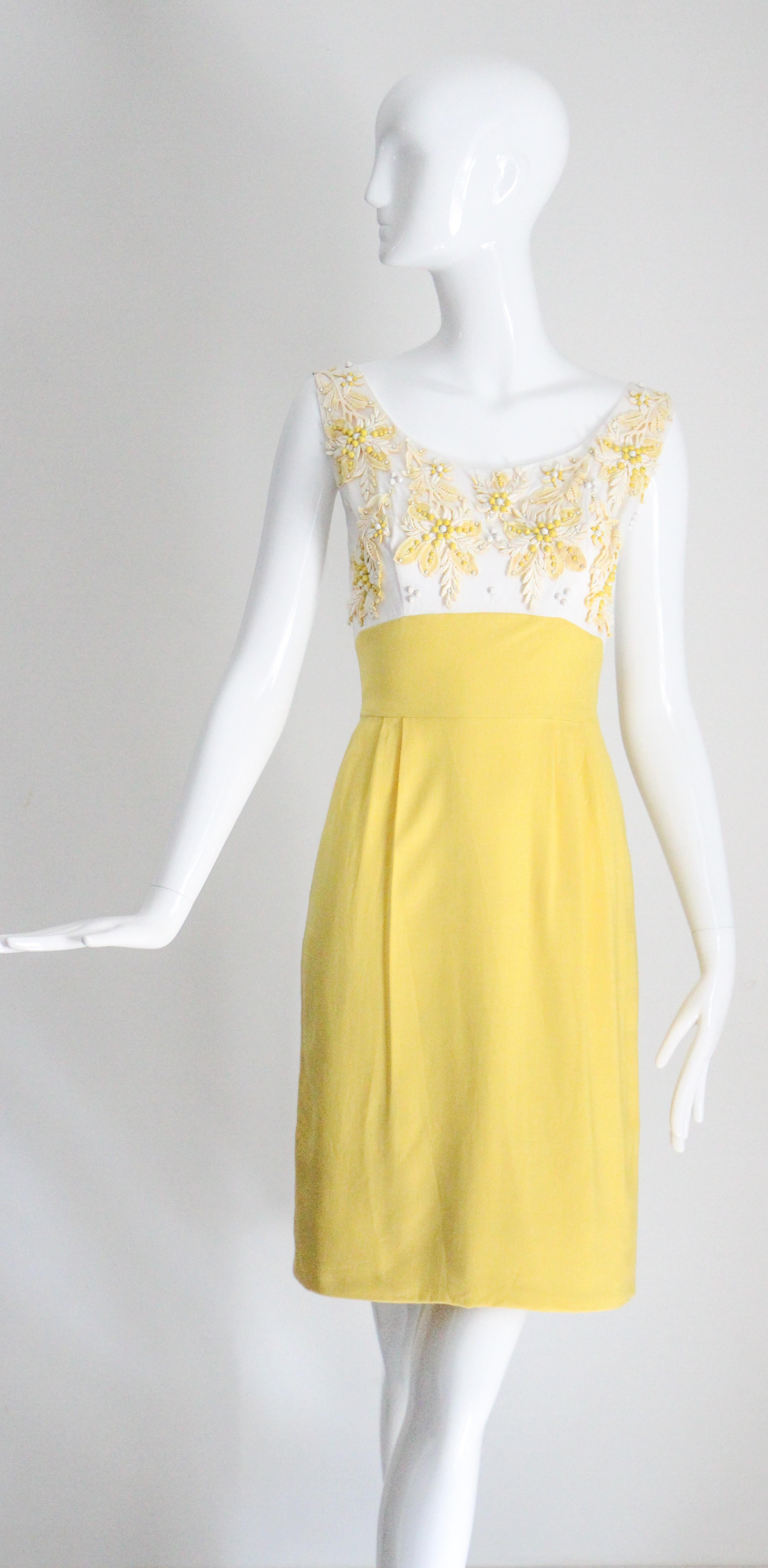 Rendered in the most joyful shade of canary yellow contrasted by a white linen bodice which is intricately decorated with floral lace appliqués and metal studs, this original 1950's linen mix dress and jacket ensemble is the perfect addition to your