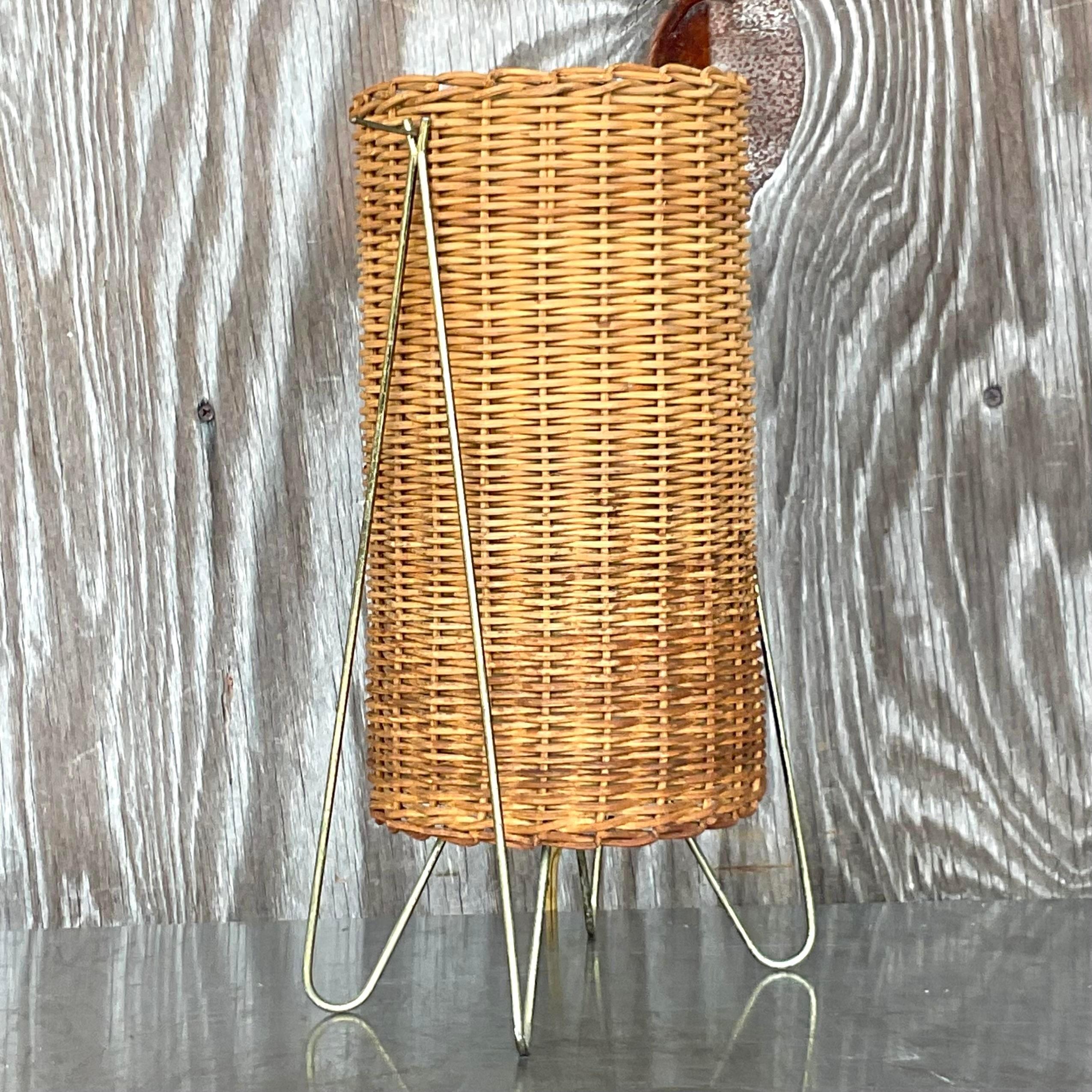 A striking vintage Coastal table lamp. Designed by the iconic Paul Mayen group. Festered in the 1952 MOMA collection. A chic woven rattan cylinder with brass hardware. Acquired from a Palm Beach estate. 