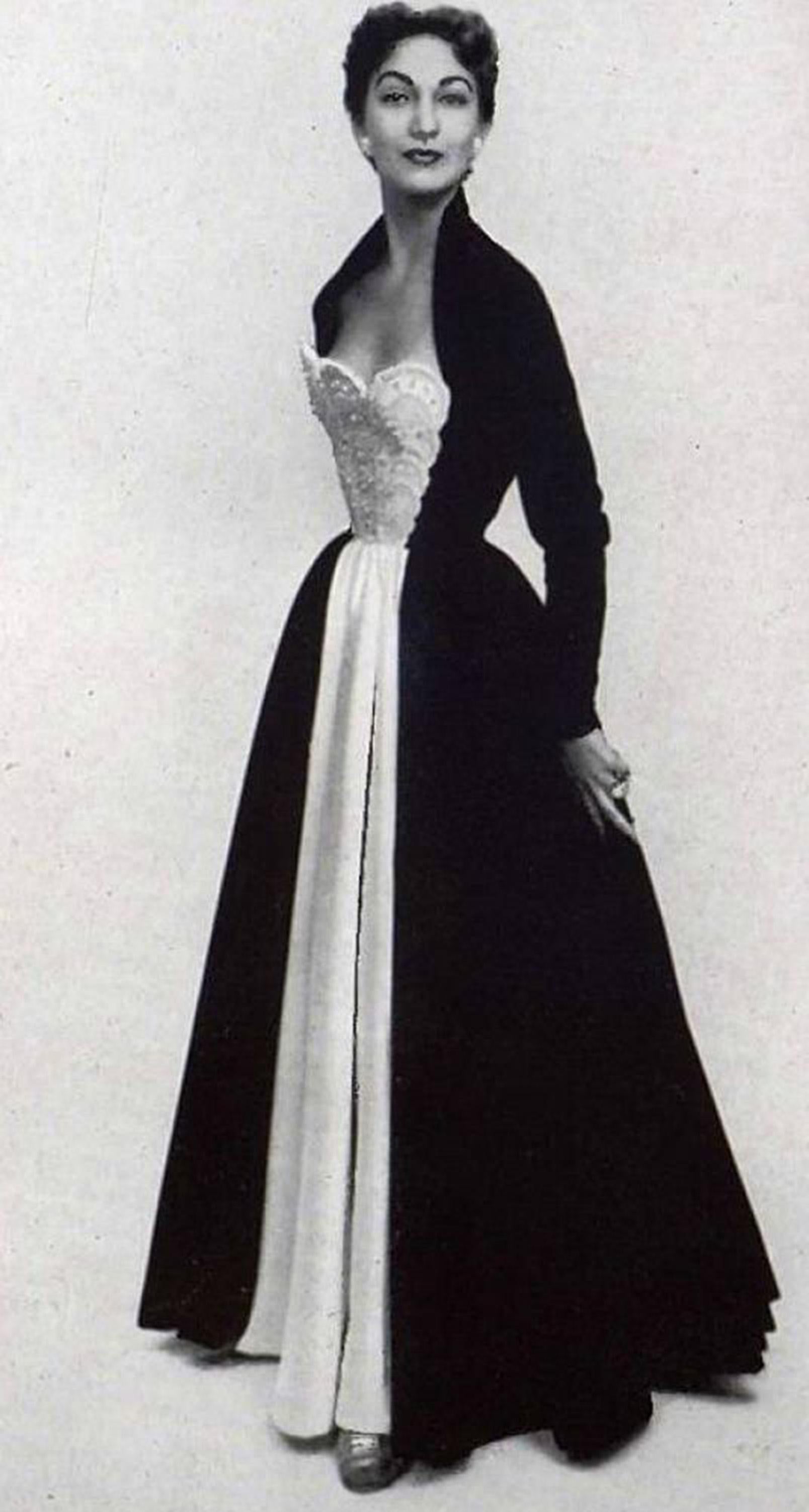 An absolutely magnificent and incredibly rare, documented Nina Ricci haute couture black velvet and ivory satin gown back to her stunning 1952 fall-winter lifetime collection. This French fashion house, known for its feminine, ladylike clothing, has