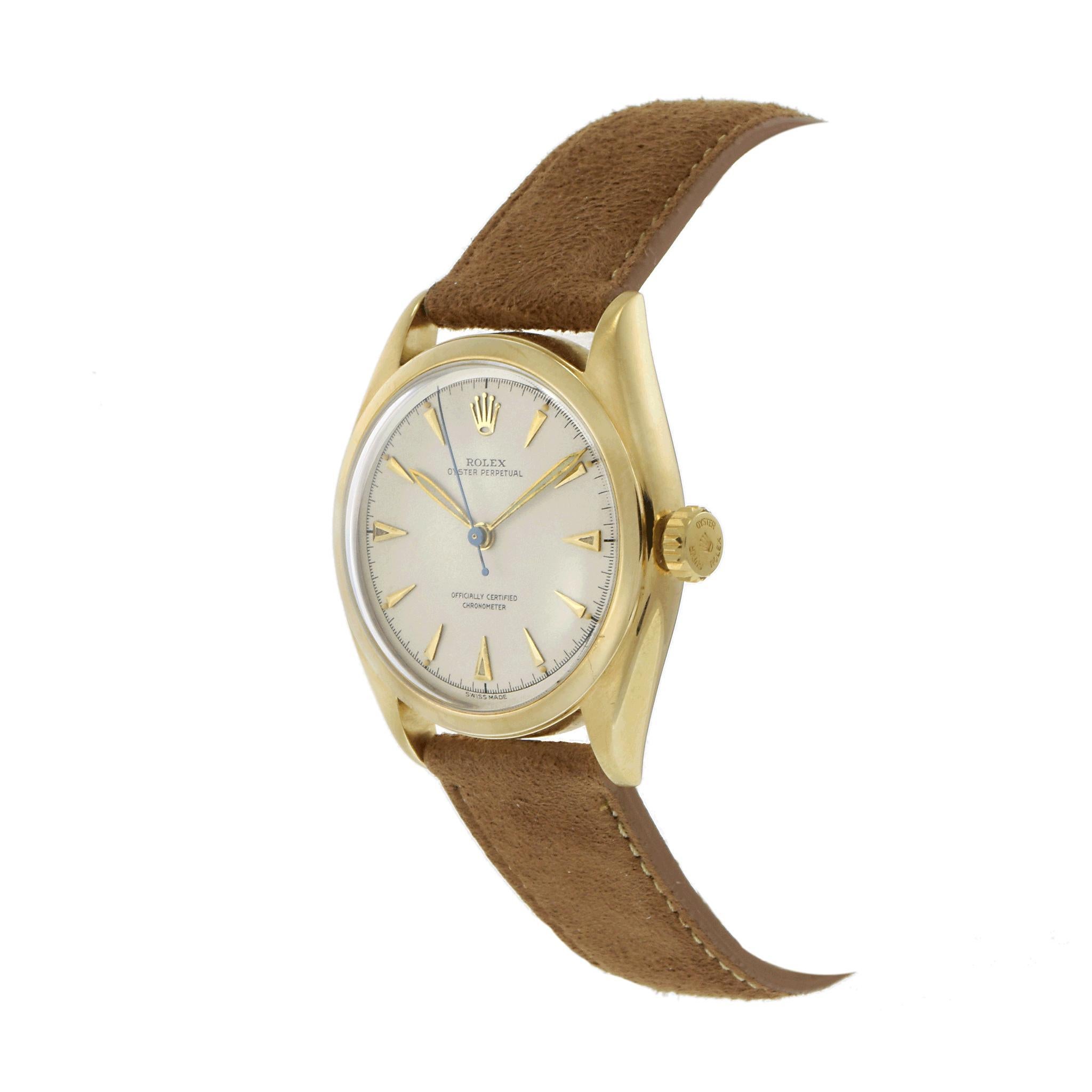A highly collectible 1952 Rolex Oyster Perpetual Bubble Back Ref. 6084, featuring a 34mm 14K yellow gold case with a classic smooth bezel, embodying the refined design of early Rolex automatic watches. The beige dial is elegantly appointed with gold