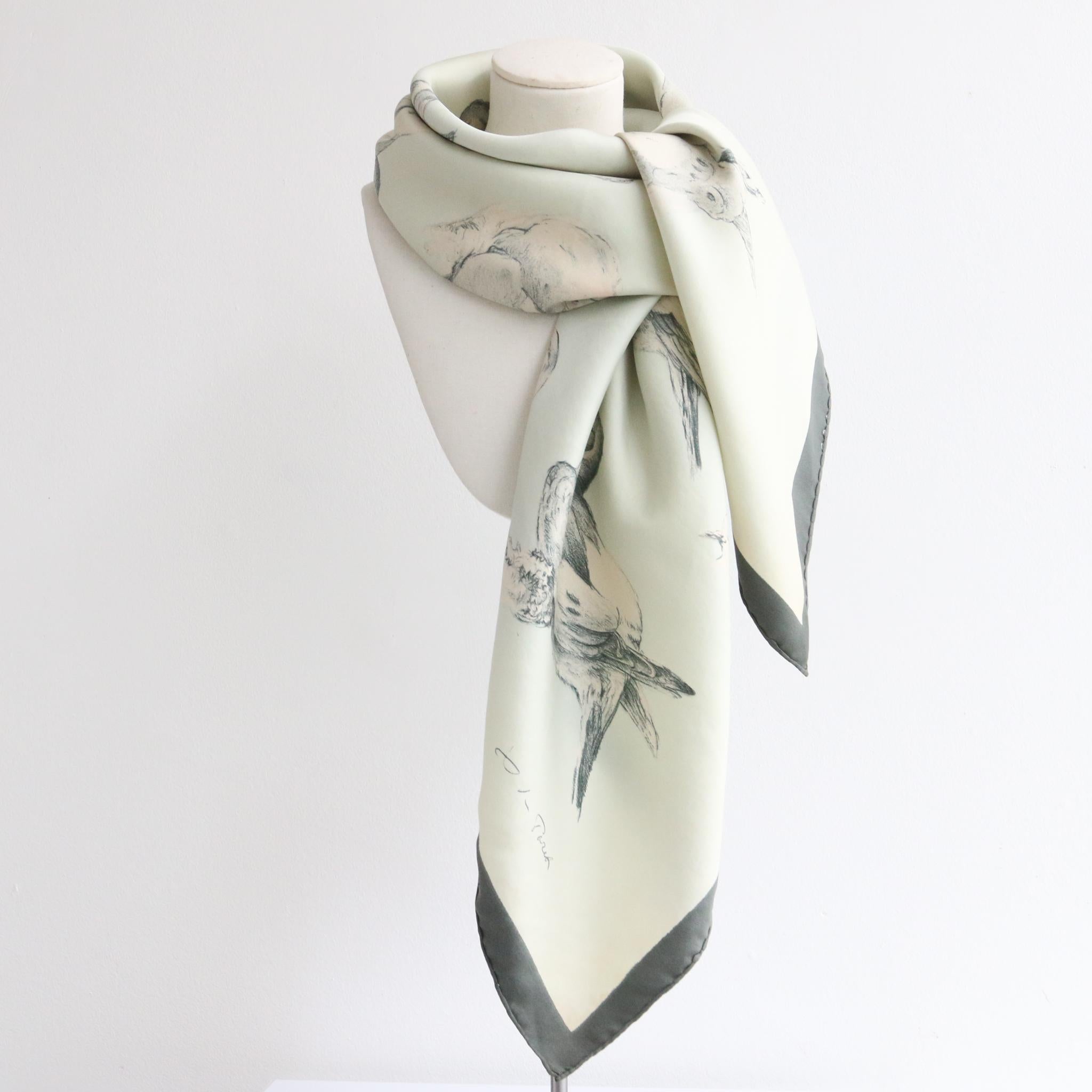This rare 1956 silk Hermès scarf, designed by Xavier De Poret is the perfect treasure for your wardrobe.

In a light duck egg blue with a dark teal trim, this beautiful scarf is adorned with sketched illustrations of turtle doves in a dark teal,