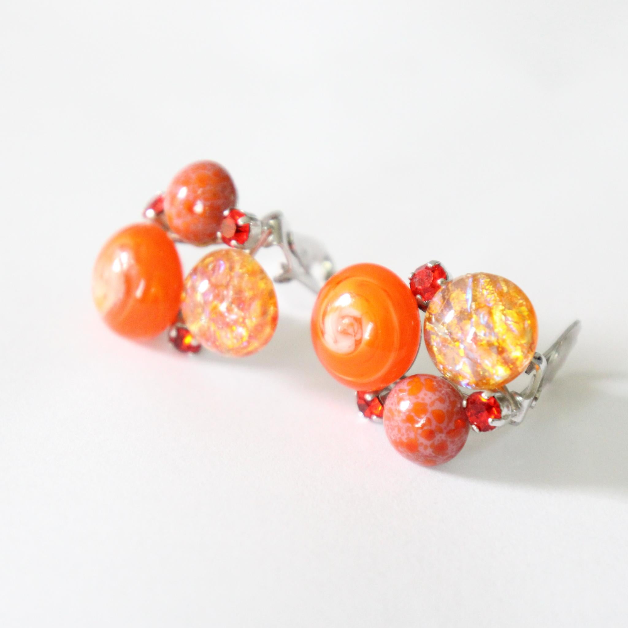 Este maravilloso par de pendientes de clip de Christian Dior, que datan de 1958, son un conjunto raro de contemplar y que nunca más volverás a encontrar.
Formados por brillantes de cristal engastados en un vibrante tono coral, que rodean 2 piedras