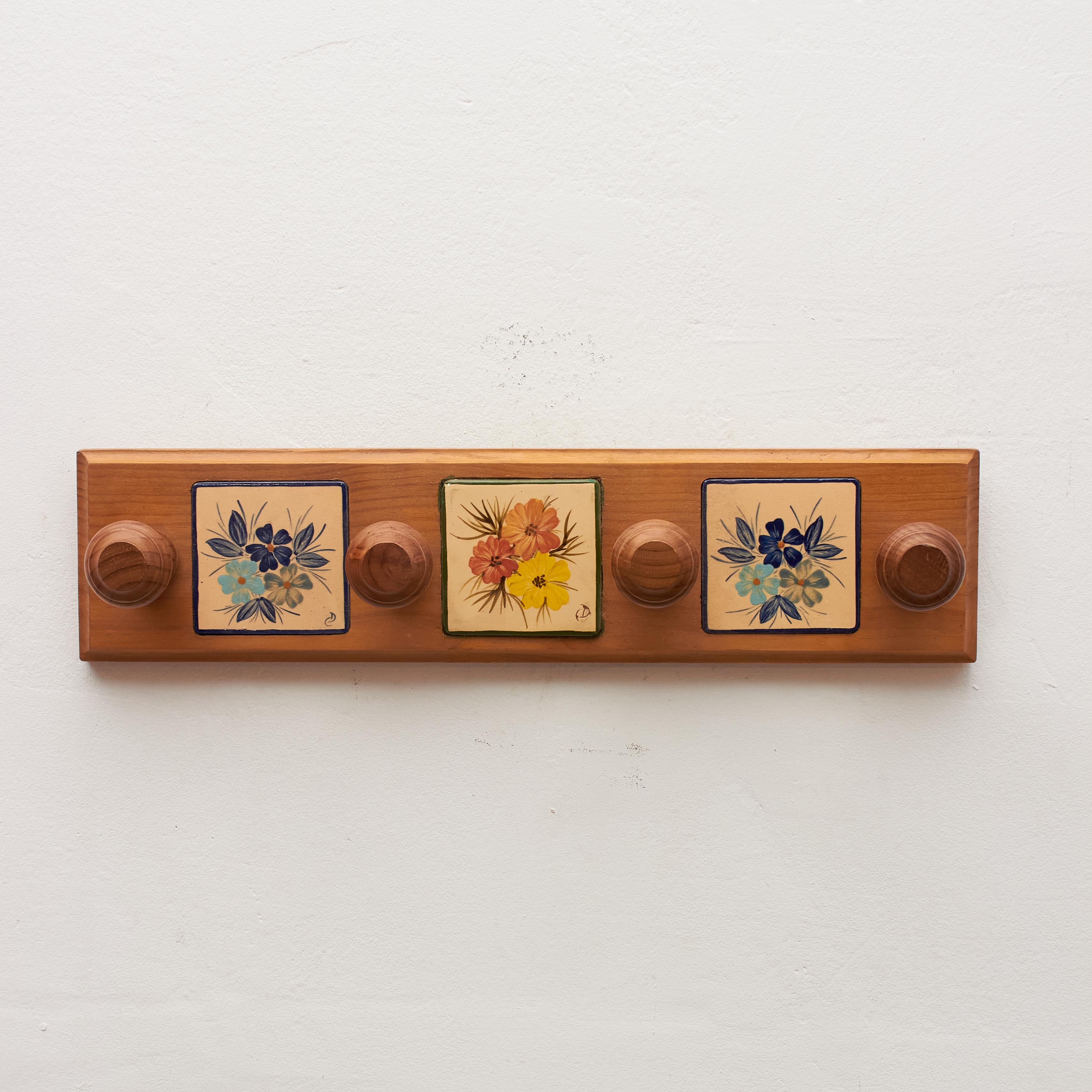 Elevate your space with the timeless craftsmanship of Catalan artist Diaz Costa through our vintage hand-painted ceramic and wood hanger, crafted around 1960 in Spain. This traditional piece is a testament to Diaz Costa's artistic flair, blending