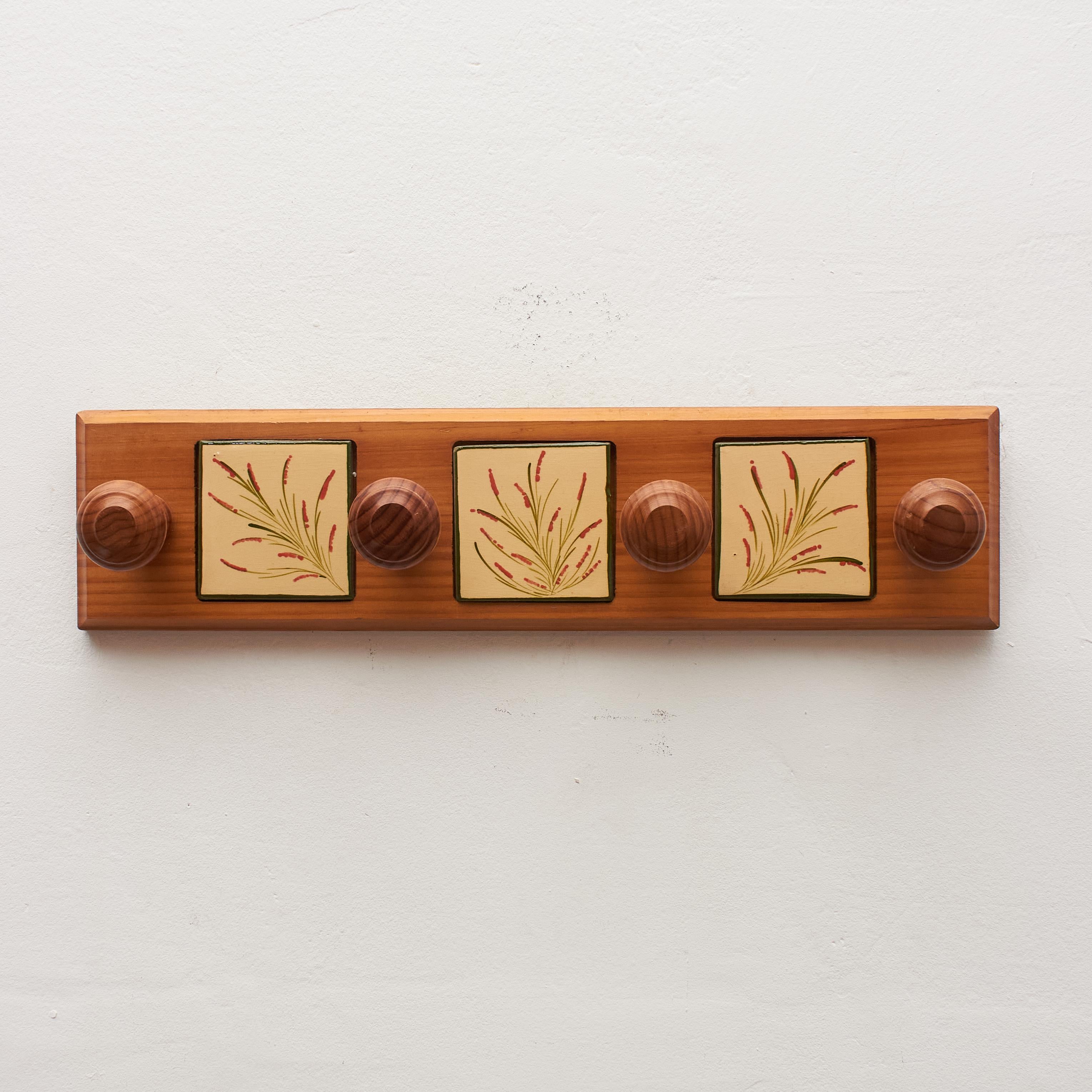 Elevate your space with the timeless craftsmanship of Catalan artist Diaz Costa through our vintage hand-painted ceramic and wood hanger, crafted around 1960 in Spain. This traditional piece is a testament to Diaz Costa's artistic flair, blending