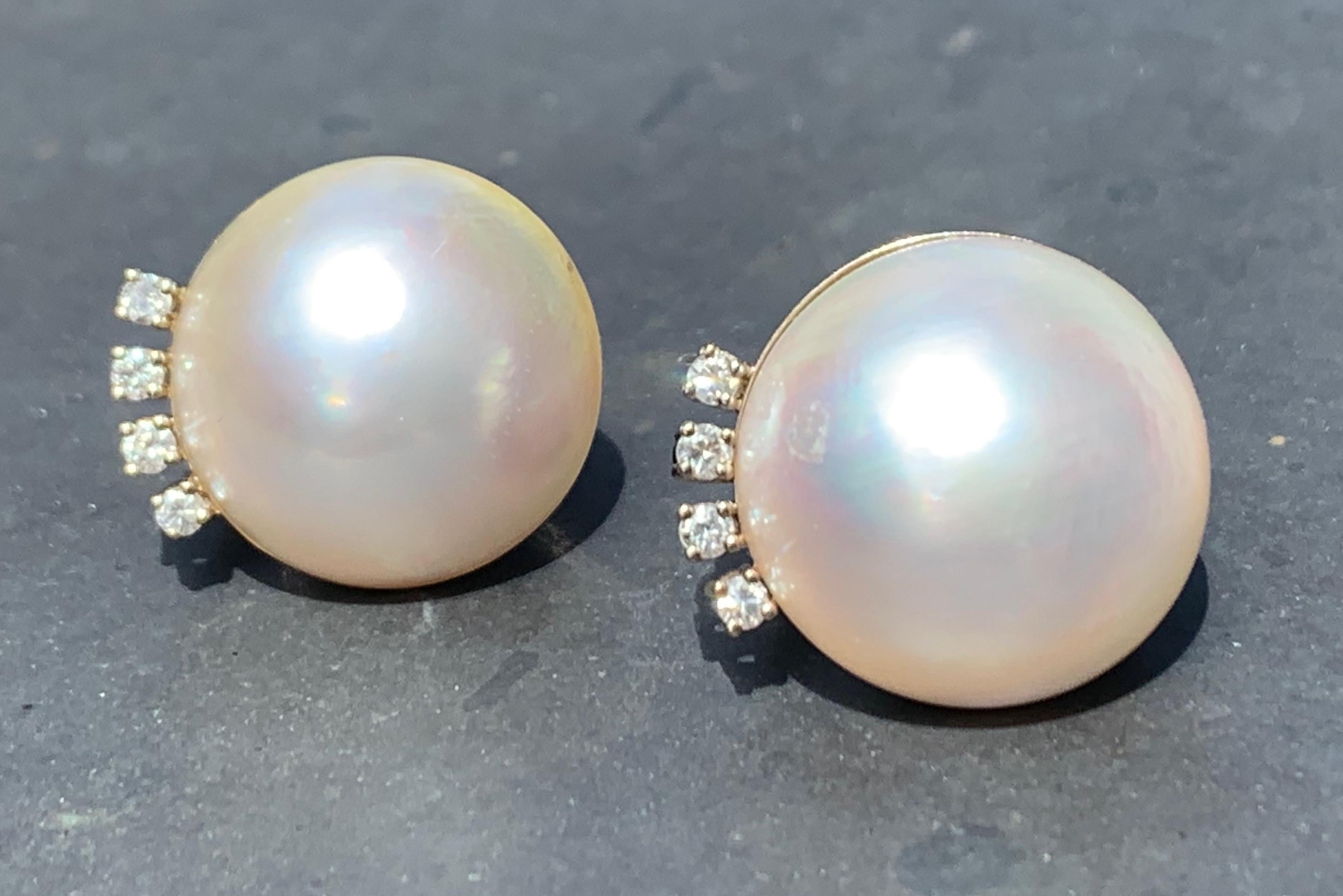 Elegant pair of mabé and diamond clip on earrings. The earclips have been crafted in 1960 ca. in 18 carat white gold and are decorated with four round cut diamonds in claw settings. The pearls have a diameter of 1.6 cm.
