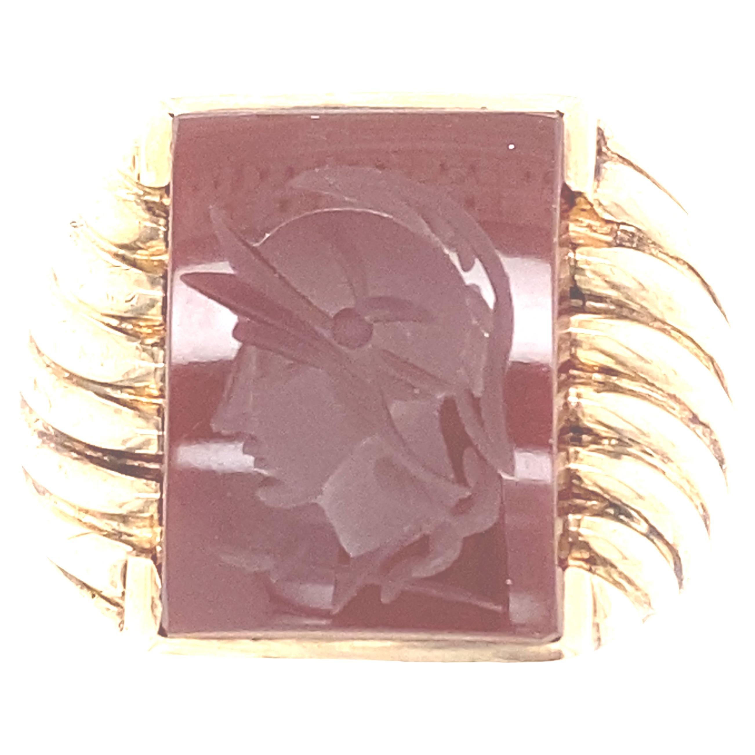 This captivating vintage circa 1960s ring features a 1/4 bezel set rectangular carnelian, the reddish-orange version of chalcedony.  In this case, the stone has been carved inwards, in the classic Italian fashion, with the profile of a Roman