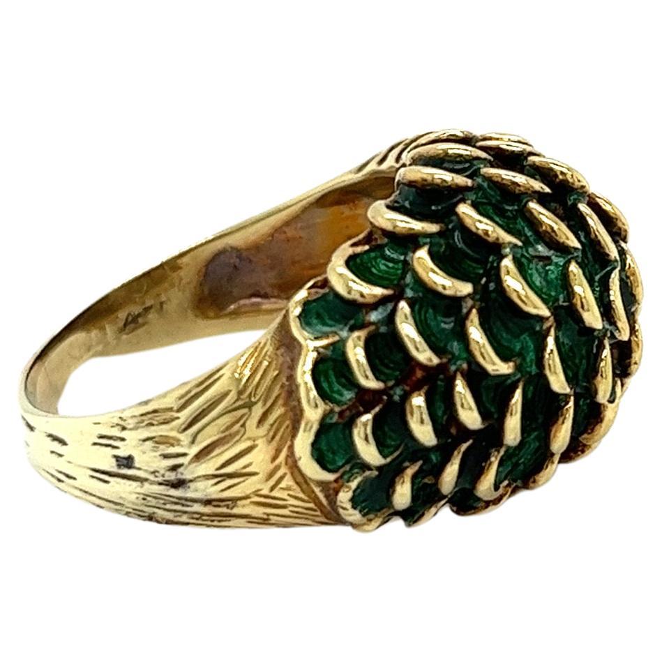 This striking statement ring is a bold and glamorous piece from the 1960s. Crafted in luxurious 14 karat yellow gold, it features a dramatic domed design at the center. The dome is coated in a rich green enamel, giving it a vibrant pop of color. The