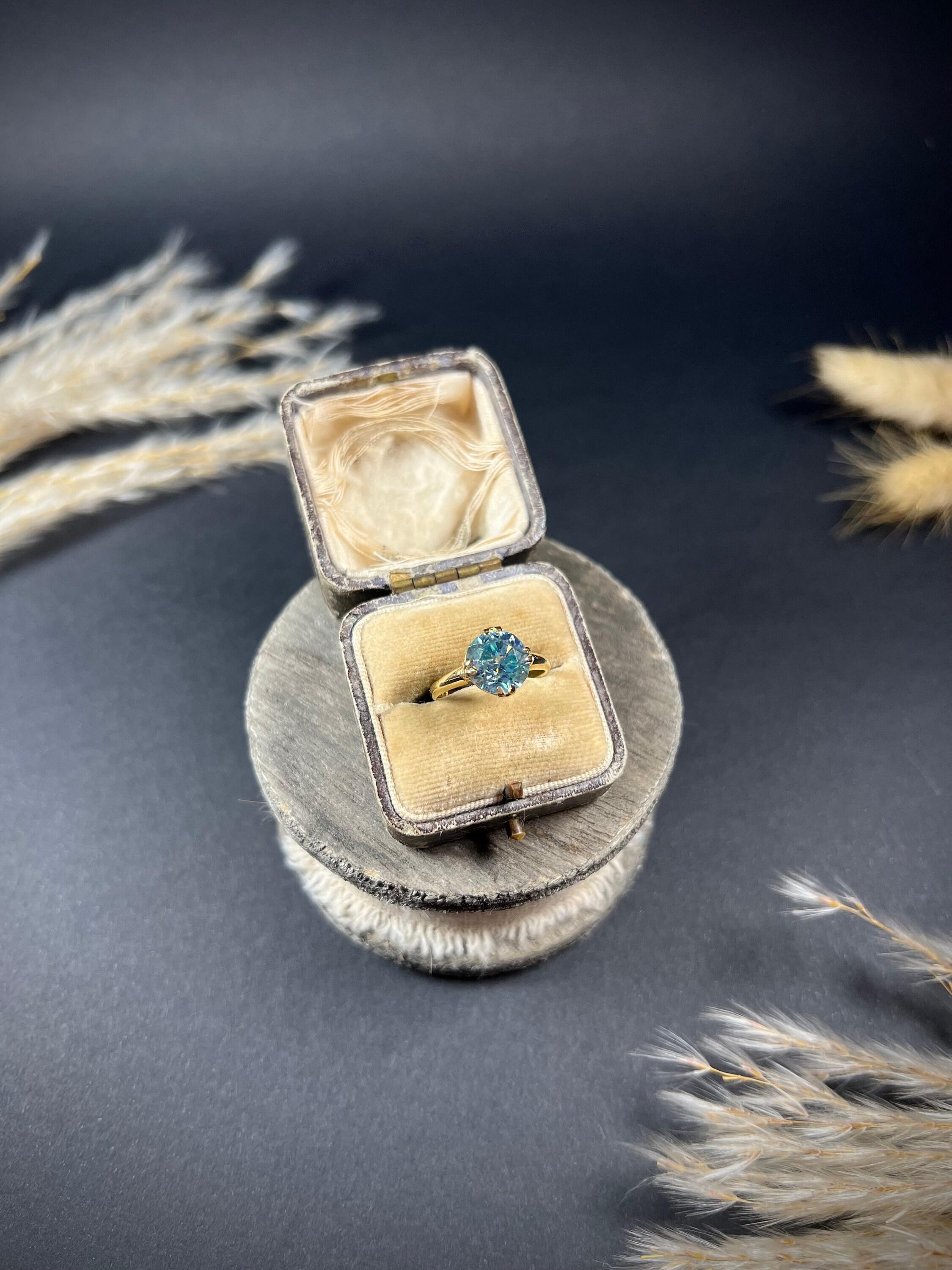 Vintage Zircon Ring 

18ct Gold Stamped

Circa 1960s

This exquisite vintage ring is the epitome of timeless elegance and sophistication. Crafted in the 1960s, this stunning piece showcases a faceted round blue zircon stone that gleams brilliantly