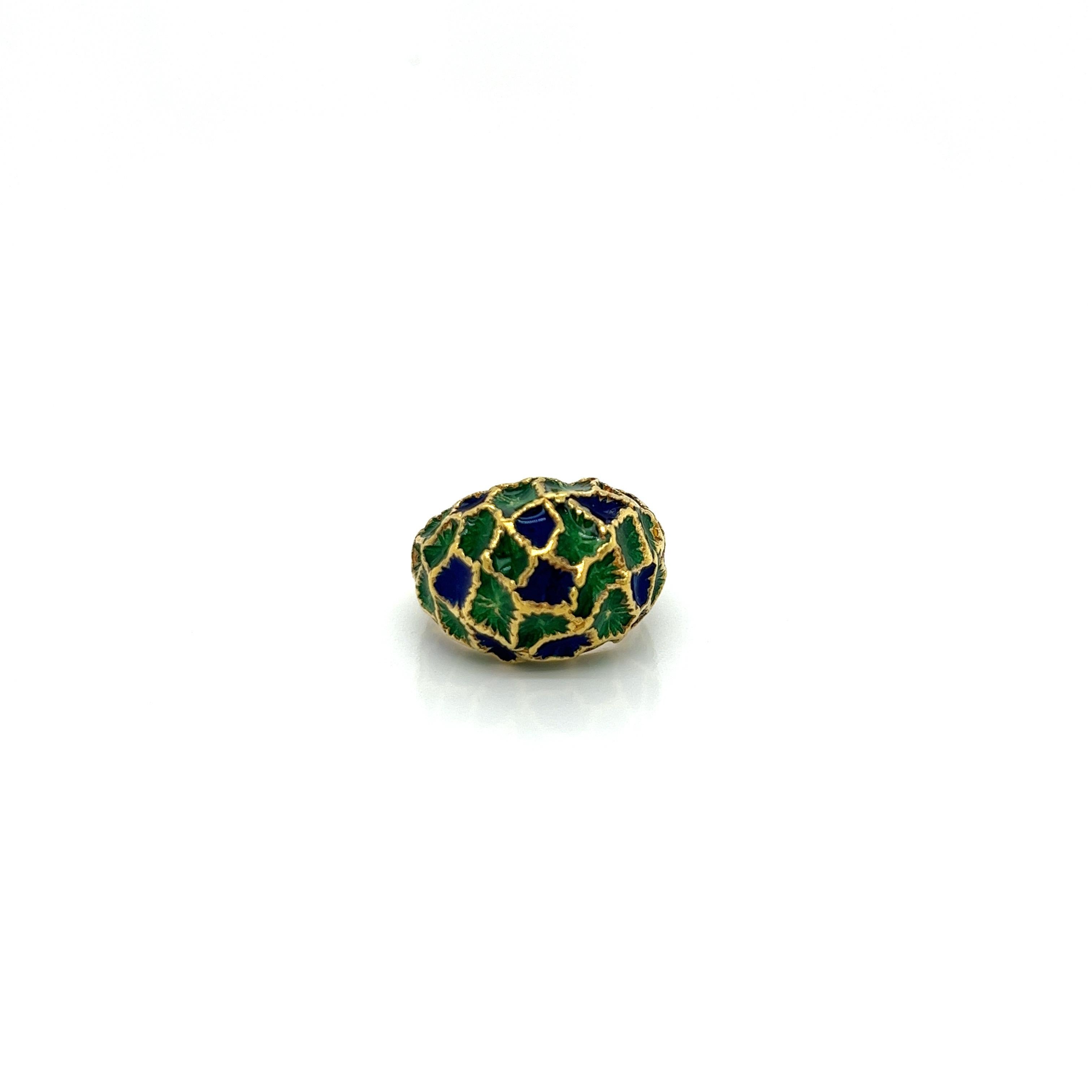 This showstopping cocktail ring is a vibrant and sculptural piece from the 1960s. Crafted in rich 18 karat yellow gold, it features a boldly domed design at the center. The dome is coated in a striking combination of blue and green enamel in a