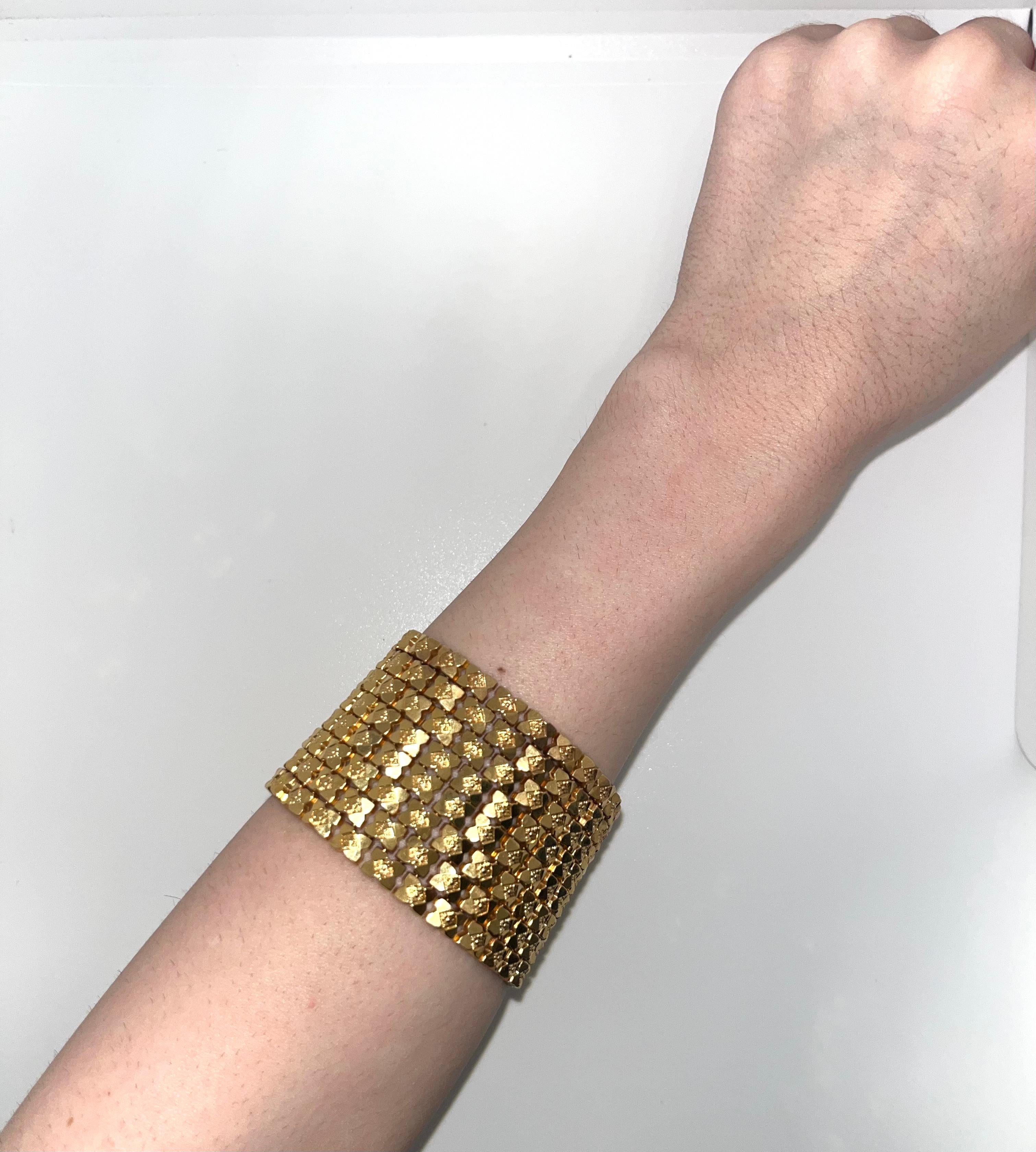 An exquisite piece from the glamorous 1960s, this Cleopatra bracelet exudes timeless elegance and opulence. Crafted from luxurious 18k yellow gold, the bracelet boasts an impressive width of 1.75 inches, spanning eight sumptuous links across the