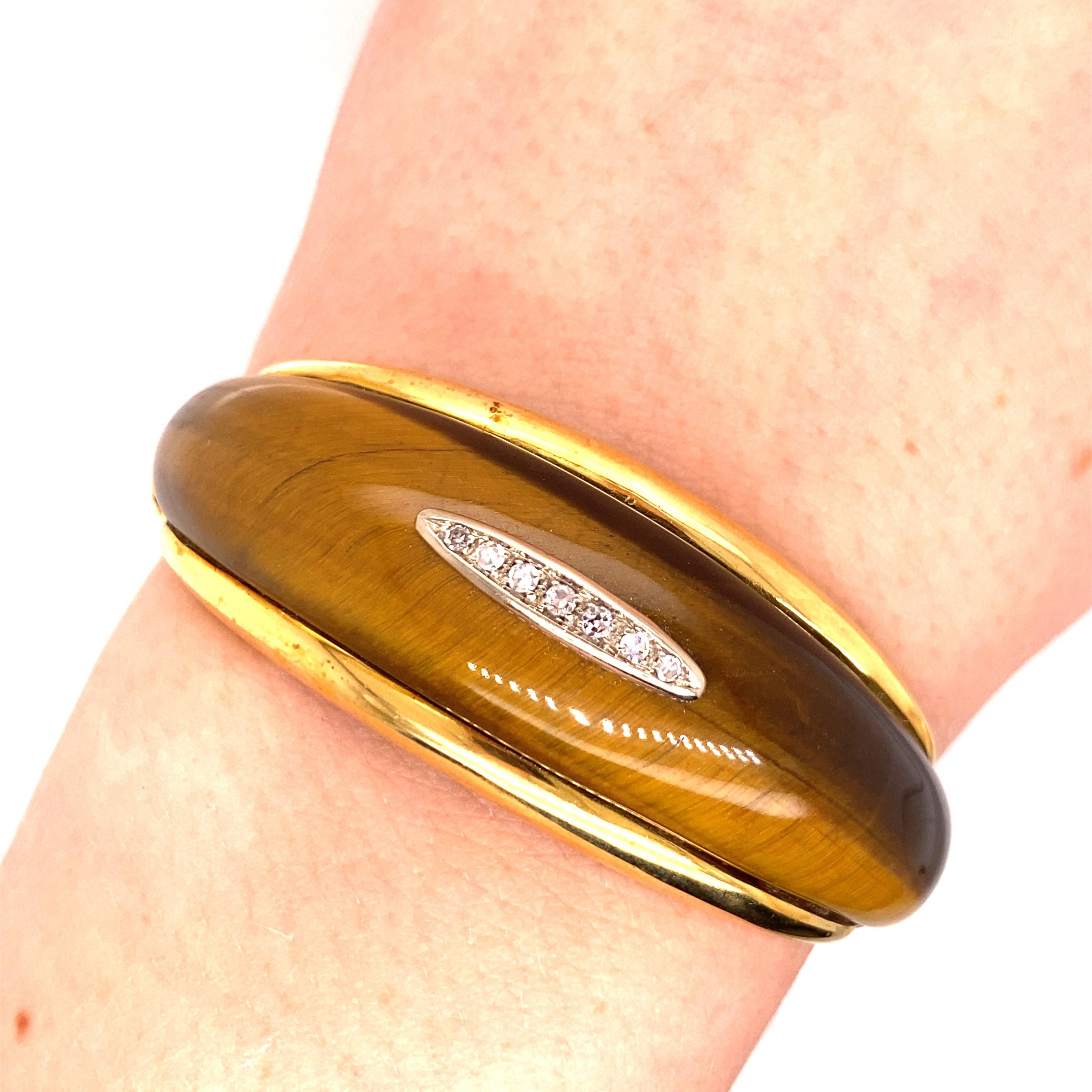 Vintage 1960's 18K Yellow Gold Tiger's Eye Bangle - The Tiger's Eye measures 2.25 inches long and .6 inches wide. There are 7 single cut diamonds set in white gold in the center of the Tiger's Eye. They weigh approximately .18ct with H-I color and