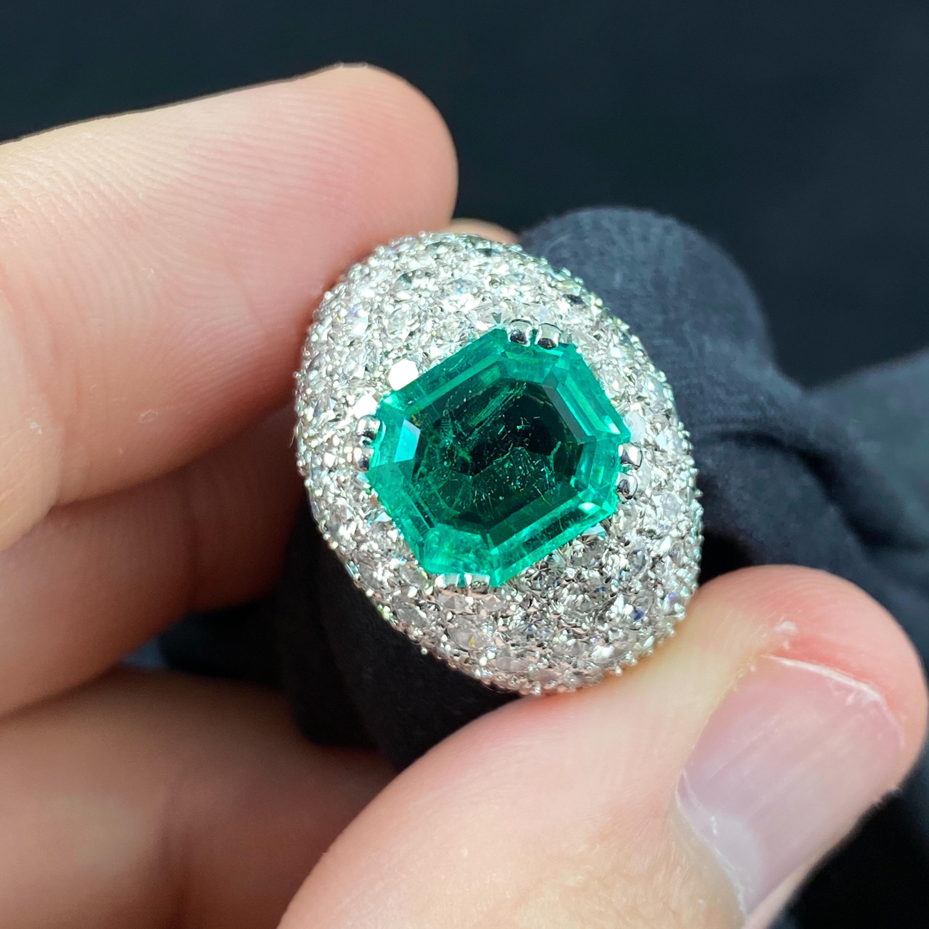 Vintage 1960s/1970s Colombian Emerald and Diamond Bombe Cocktail or Dress Ring in Platinum, Signed, Portugal. Featuring a highly transparent deep green Colombian emerald double claw-set to the centre, amidst a sea of pave-set round brilliant-cut