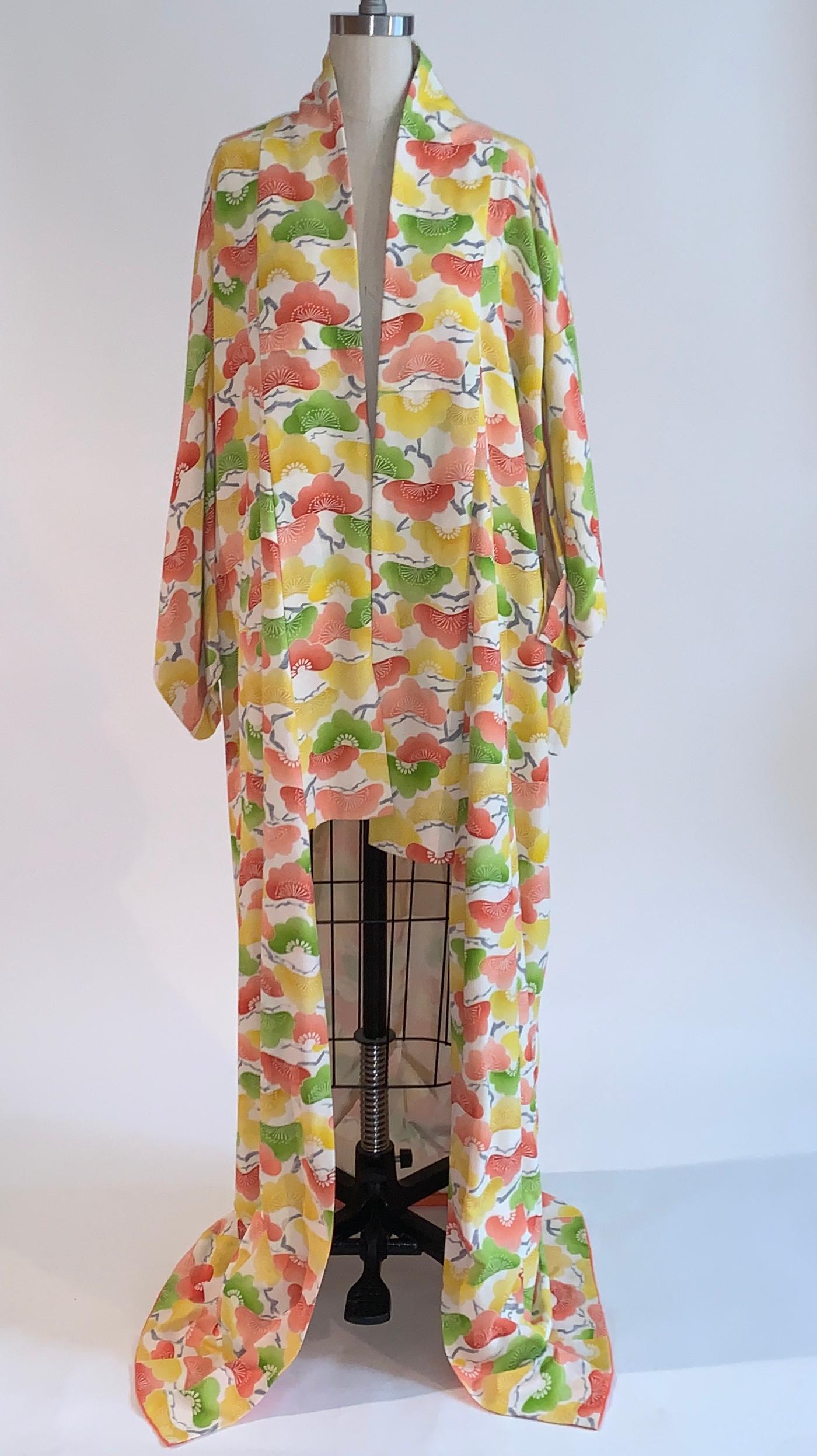 Vintage 1960s or 70s silk jacquard kimono with a cheerful pink, green, and yellow print that looks like abstract fans or florals. Vibrant pink dip dyed silk lining at interior bottom. Great with a t-shirt, wedges, and slim jeans. 

One size. 

Good