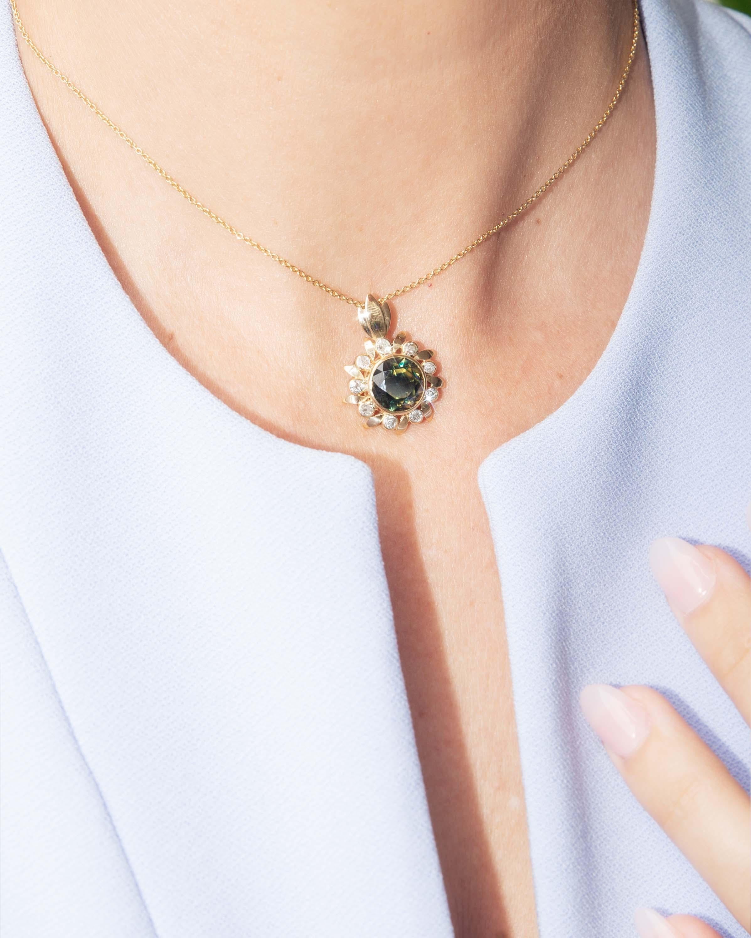 Incarnant l'étreinte du soleil, le pendentif Adil en or jaune 18 carats brille avec un saphir Parti de 4,65 carats, rayonnant de bleus et de verts, associé à des diamants Old Cut étincelants. Chaque facette accroche la lumière, créant une danse de