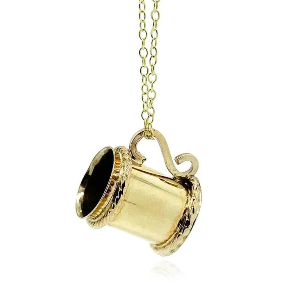 Este colgante vintage, juguetón y finamente elaborado, presenta una copa de jarra en miniatura, bellamente elaborada en oro amarillo de 9 ct macizo. Data de la década de 1960 y tiene mucho carácter, con un asa detallada y el borde grabado, evocando