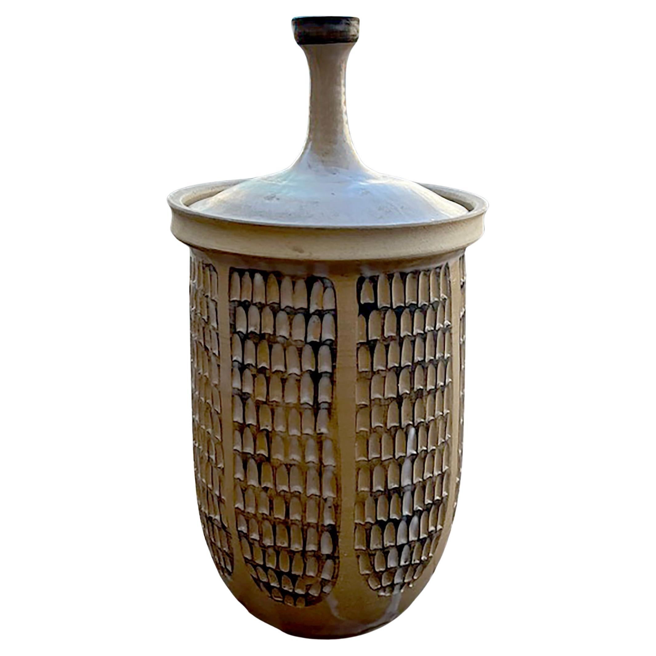 Jarre à couvercle en poterie de studio américaine par le céramiste Todd Warner, vers 1962.  Le bocal est doté d'une  glacé à la crème, surface sculptée à la main et mesure 13