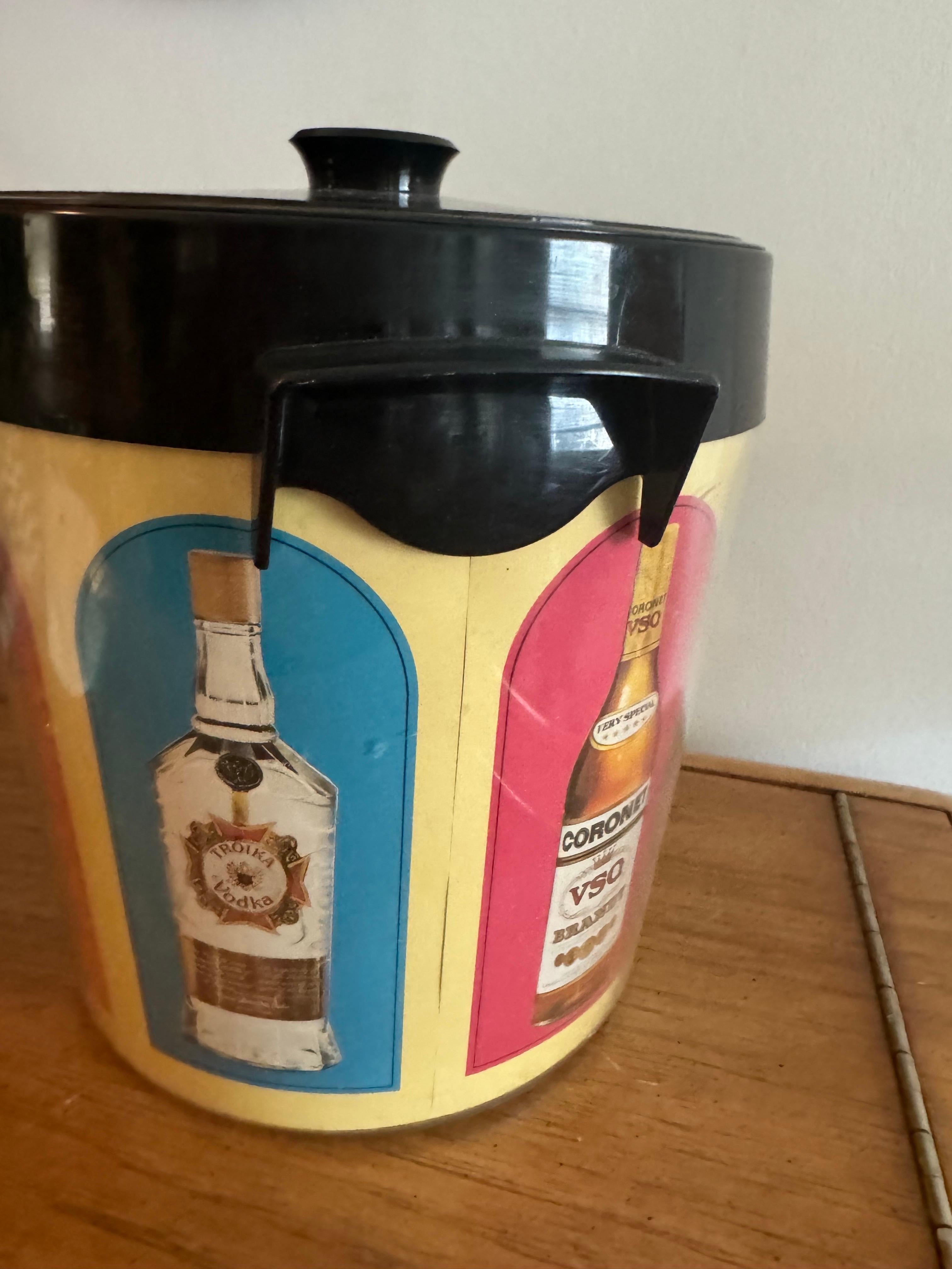 Añade un toque de encanto de mediados de siglo al bar de tu casa con esta vibrante cubitera vintage, fabricada en EE.UU. Con un atrevido diseño Retro Pop, presenta coloridas ilustraciones de varias botellas de licor, como ron y whisky, que le dan un