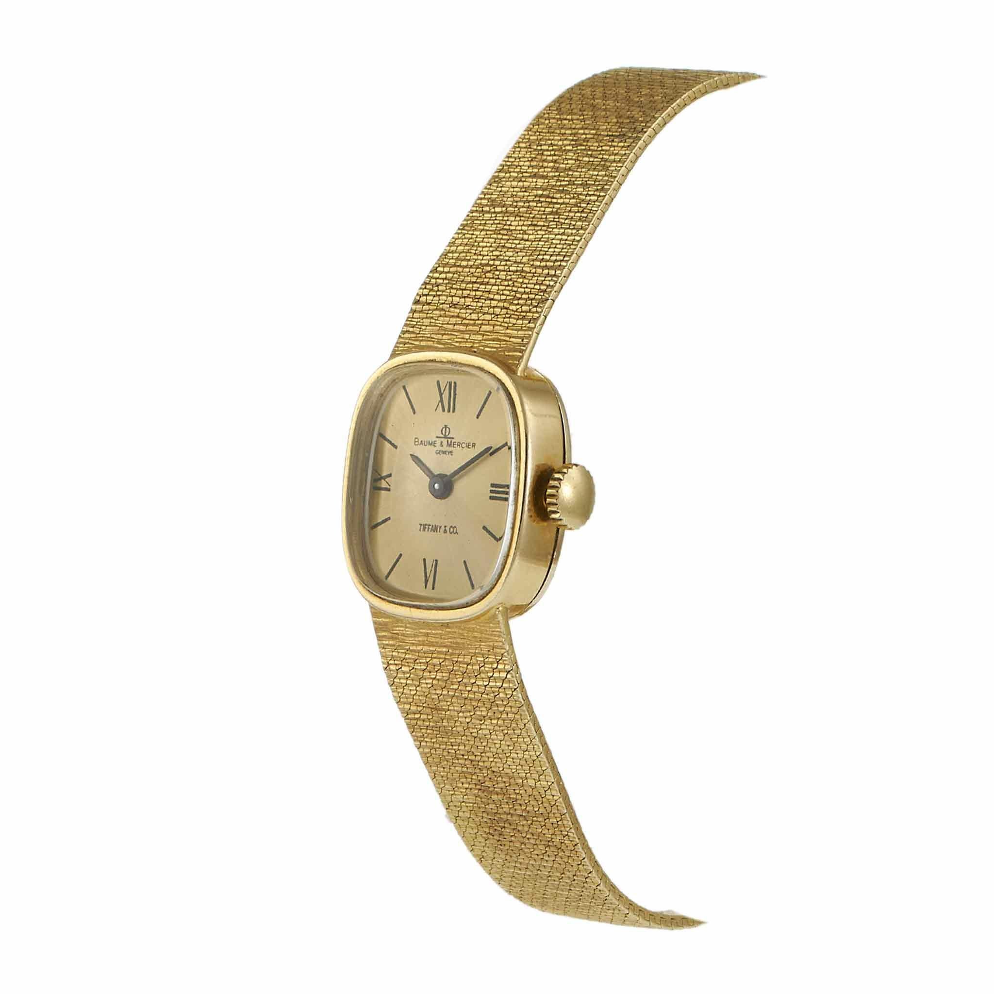 Rare et élégante collaboration entre Baume & Mercier et Tiffany & Co, cette montre cocktail vintage des années 1960 présente un boîtier en or jaune 14KT de 17,5 x 21 mm associé à un bracelet à maillons intégrés. Le cadran en or est doublement signé,