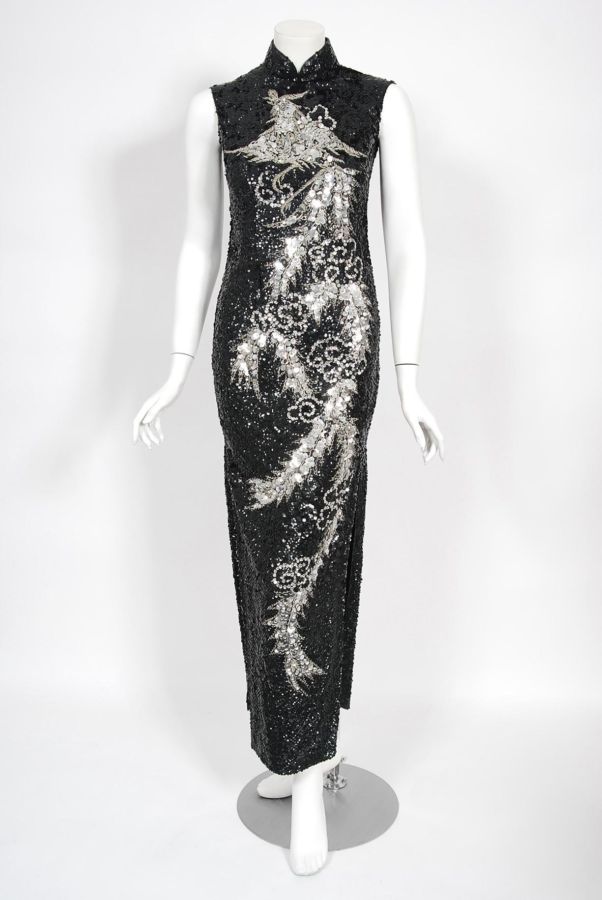 A sensational fully-sequin black & silver hourglass cheongsam gown dating back to the mid 1960's. This showgirl showstopper has fantastic three-dimensional sequins which really dazzles the eye. A dramatic flying phoenix bird motif is worked in with