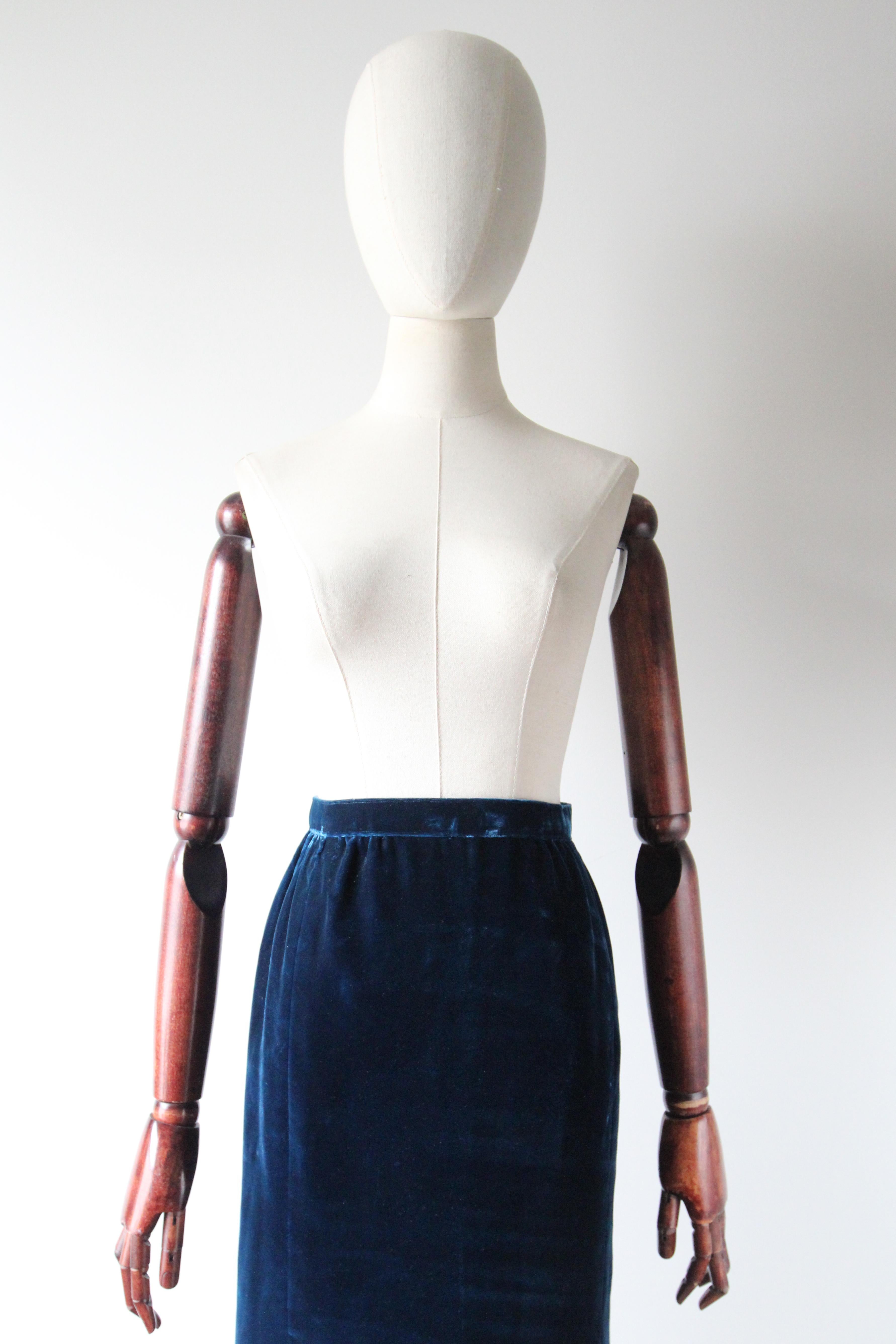 Dieser originelle Maxirock aus den 1960er Jahren ist in einem prächtigen preußischblauen Samtton gehalten und ist genau das richtige Stück für Ihre Garderobe. Der schlichte Bund lässt sich am hinteren Teil des Rocks mit Reißverschluss und Häkchen