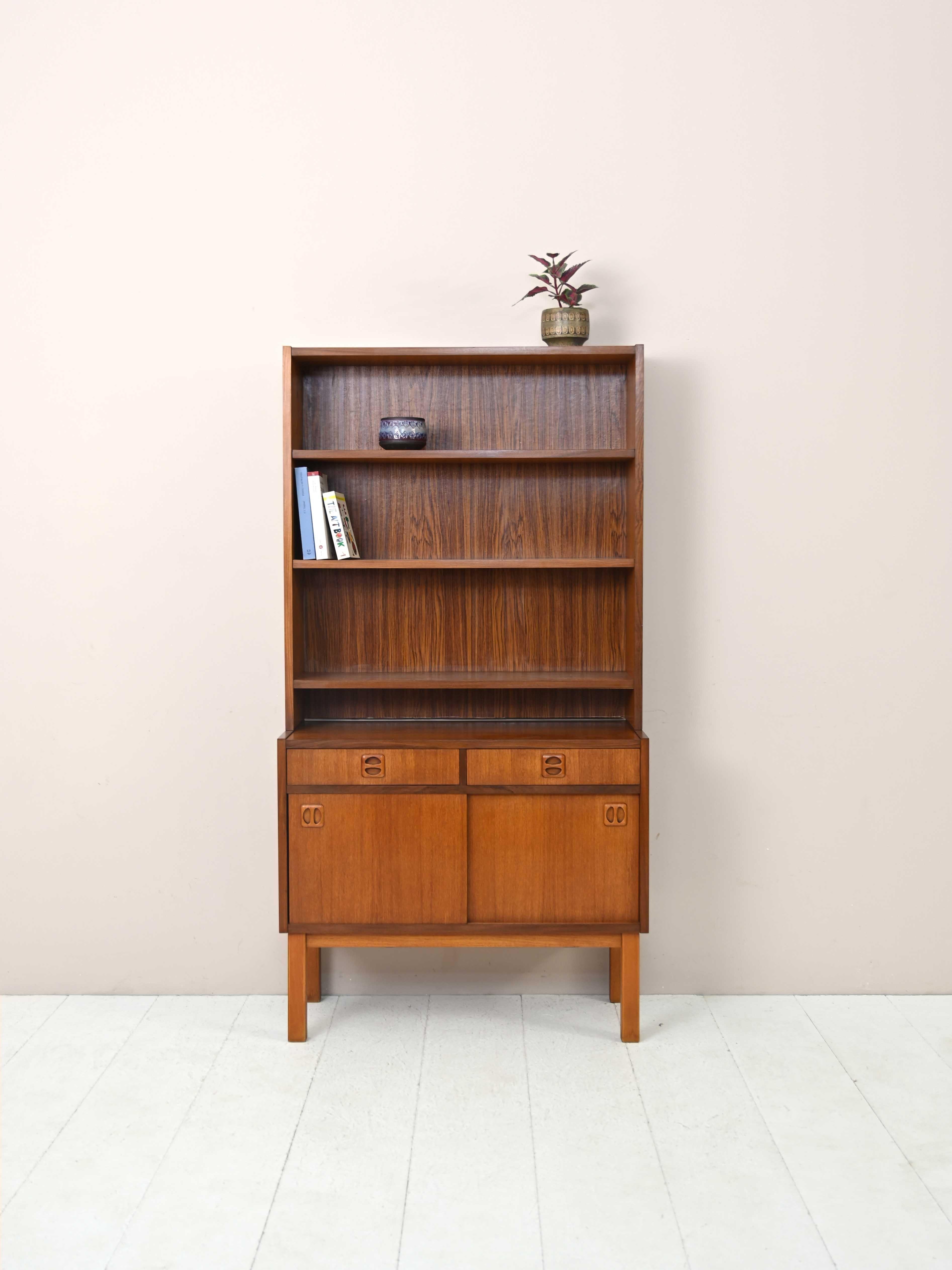 Scandinavian cabinet with shelving.

A practical and original bookcase consisting of a cabinet with sliding doors and two drawers and an adjustable-height shelving system.
The unmistakable features of the Bodafors company's furniture can be found in